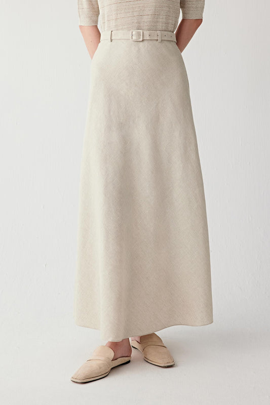 Front view focusing on the long flared silhouette and hemline, emphasizing the fluid movement and softly structured drape created by the plain-woven linen fabric
