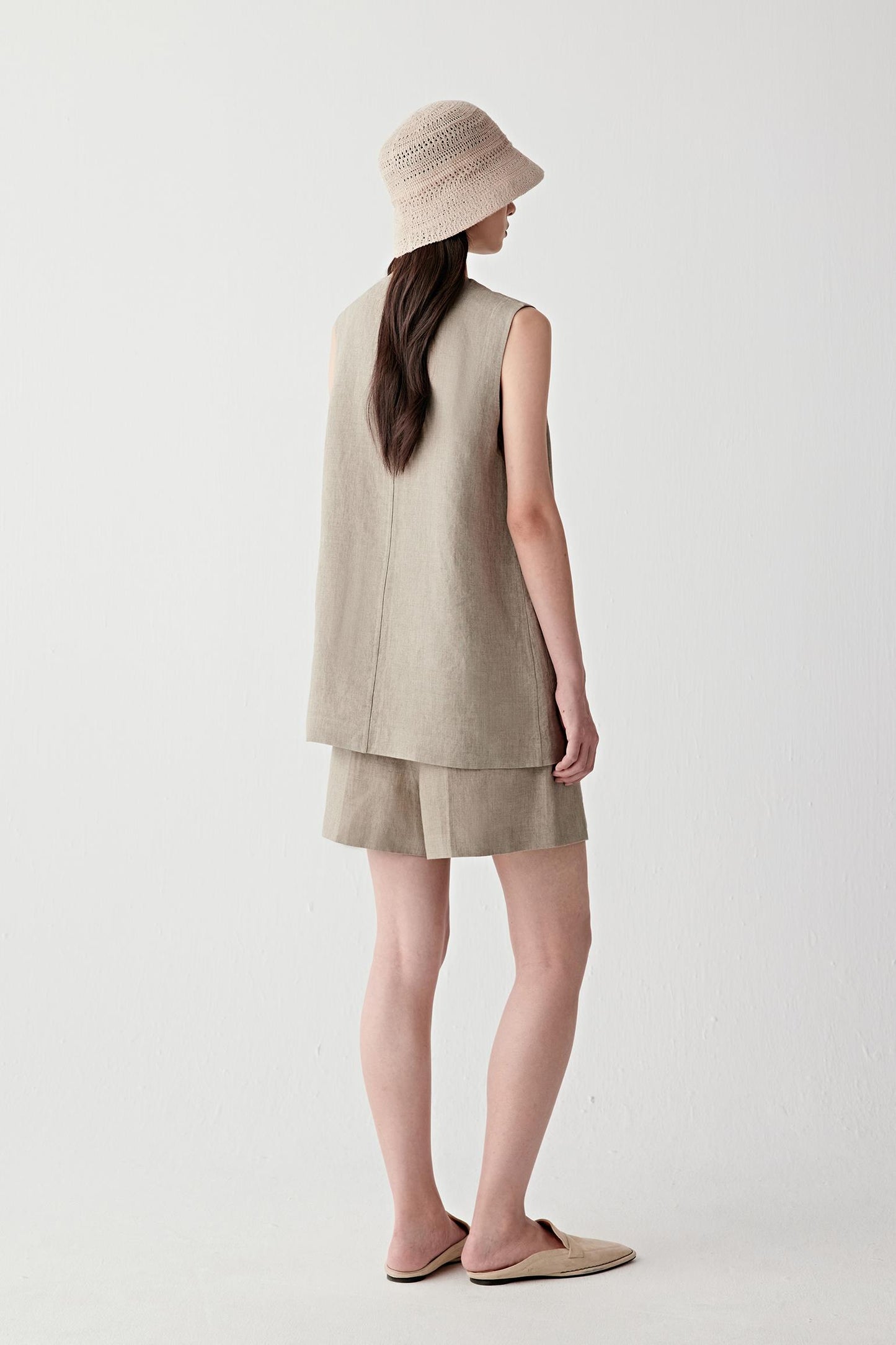 Full-length side or back view highlighting the elongated silhouette, clean sleeveless cut and soft movement created by the lightweight plain-woven linen construction