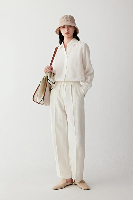Front or three-quarter view emphasizing the classic collar, button fastening and long sleeves, showing the soft movement and airy construction of the linen fabric