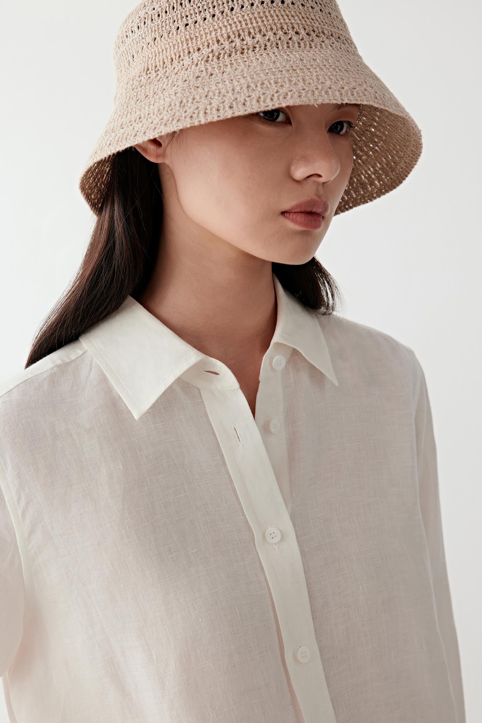 Close-up portrait focusing on the collar and upper construction, detailing the lightly textured weave and matte surface of the plain-woven linen