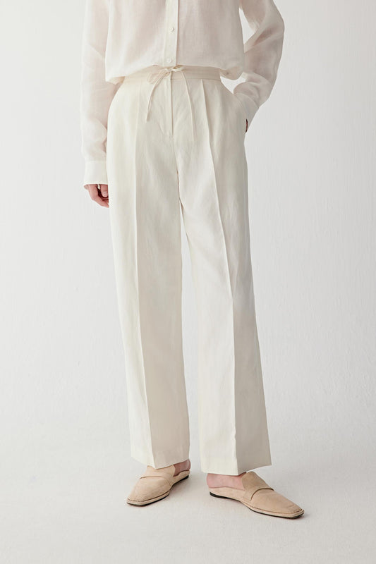 Front view focusing on the leg shape and hemline, emphasizing the clean straight-leg construction, lightweight structure and fluid movement of the undyed silk and linen fabric