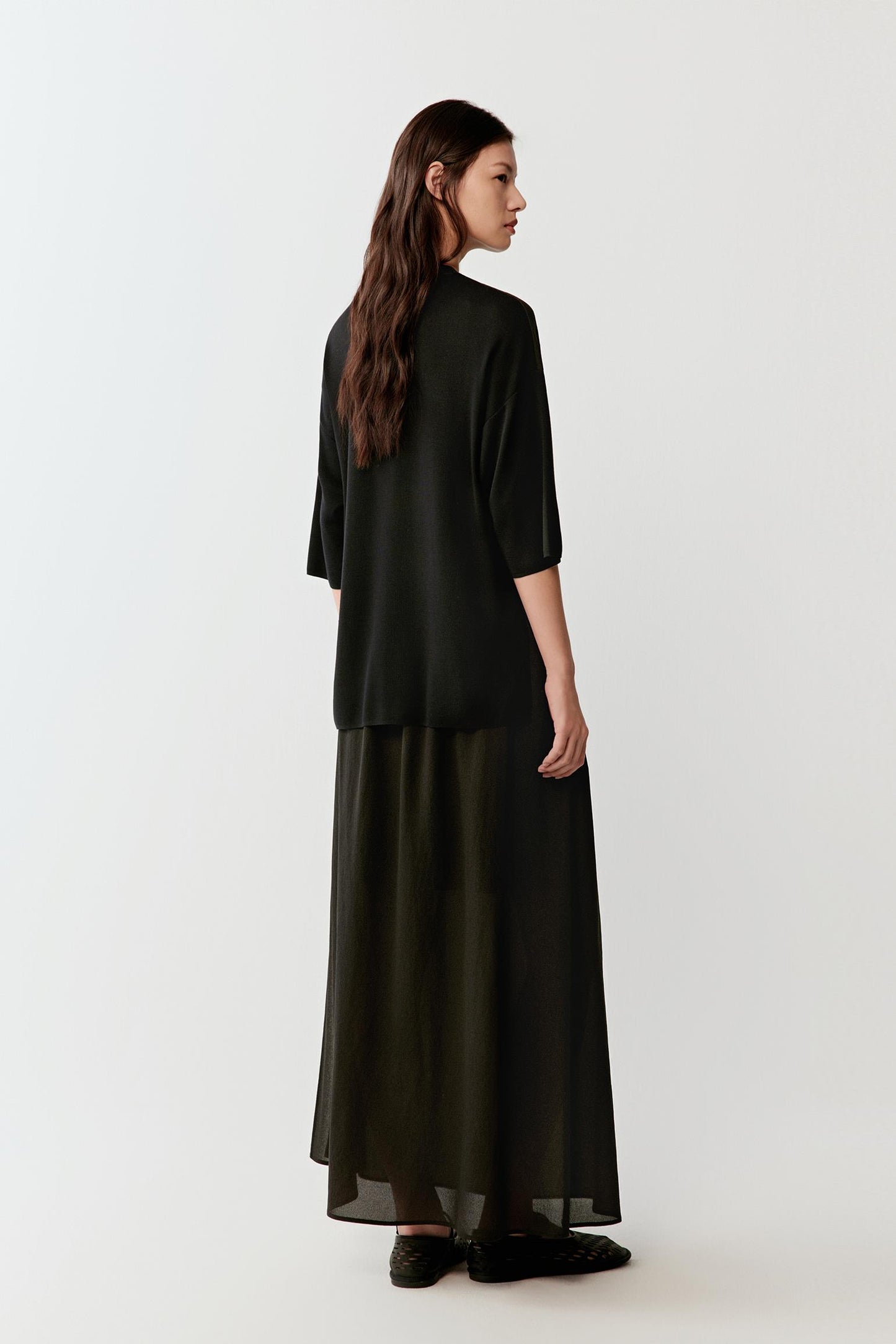 Full-length side or three-quarter view highlighting the relaxed fit, continuous drape and lightweight fluidity of the silk jersey fabric as it moves around the body