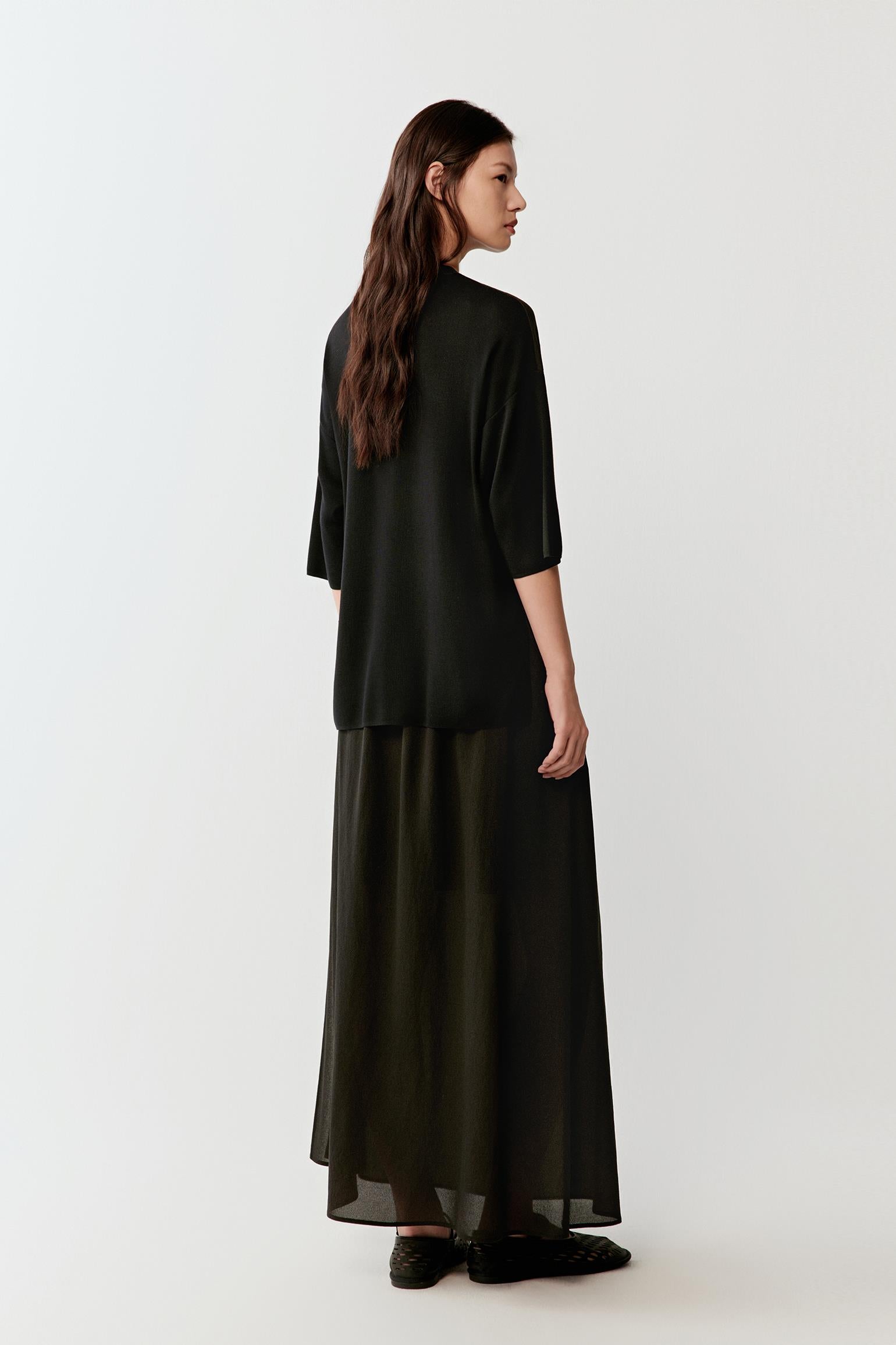 Full-length side or three-quarter view highlighting the relaxed fit, continuous drape and lightweight fluidity of the silk jersey fabric as it moves around the body