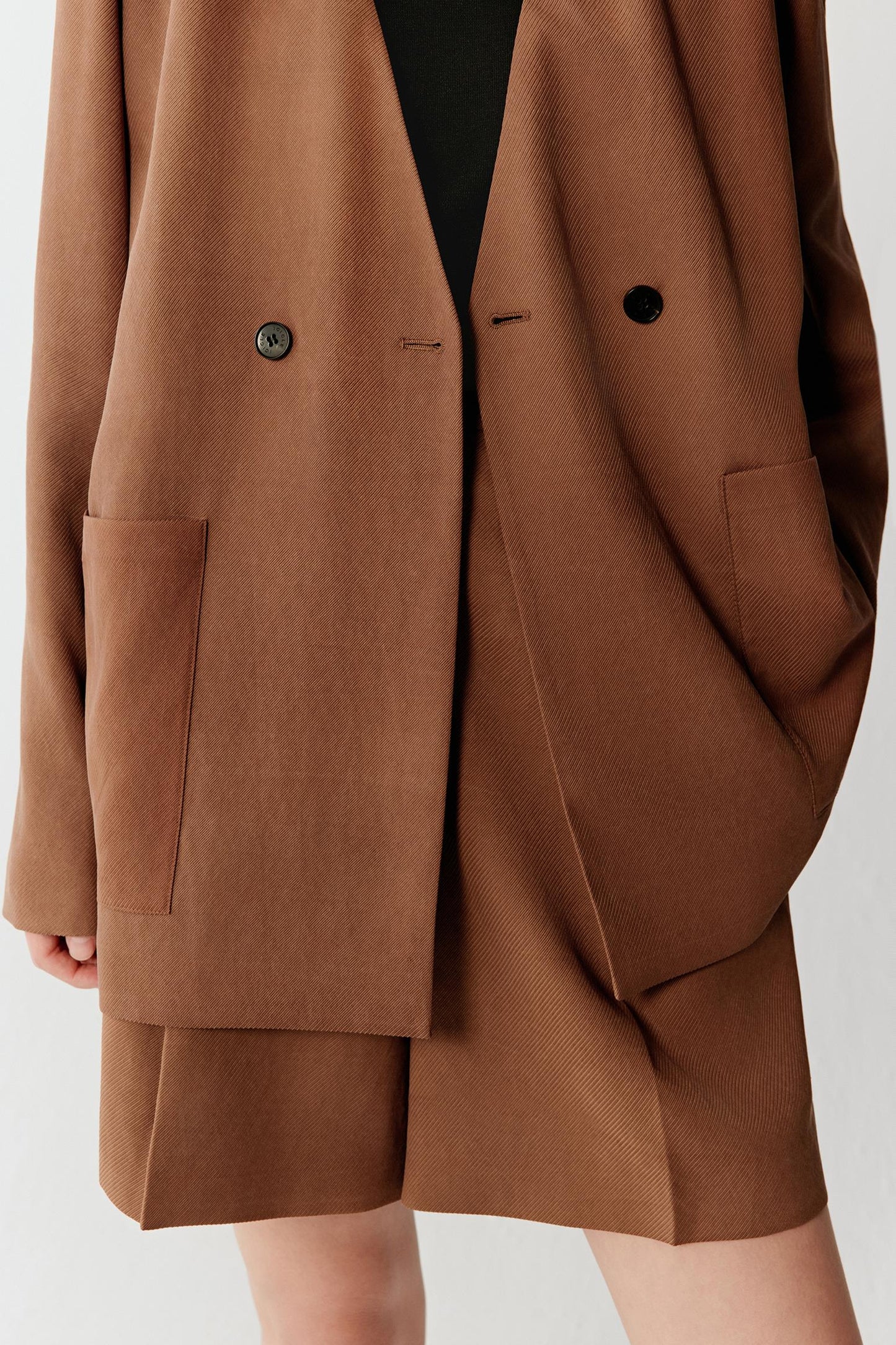 Close-up of pocket and sleeve showing the oversized patch pocket construction, visible stitching and softly textured Gambiered Canton Gauze weave with fluid drape