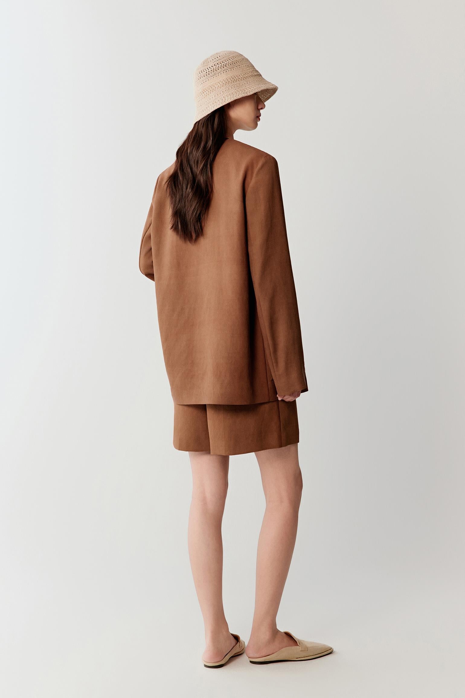 Full-length side or three-quarter view highlighting the relaxed silhouette, fluid movement and softly structured construction of the jacket as it falls around the body