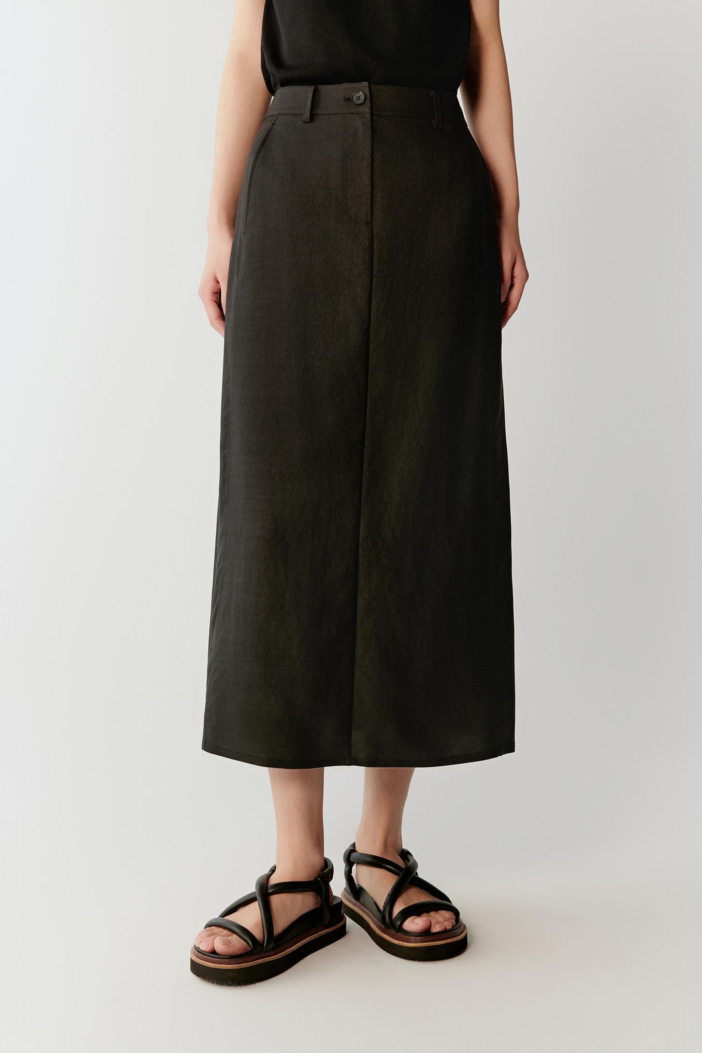 Front or three-quarter view focusing on the elongated straight silhouette and high waist construction, emphasizing the soft structure and fluid movement of the deep black fabric