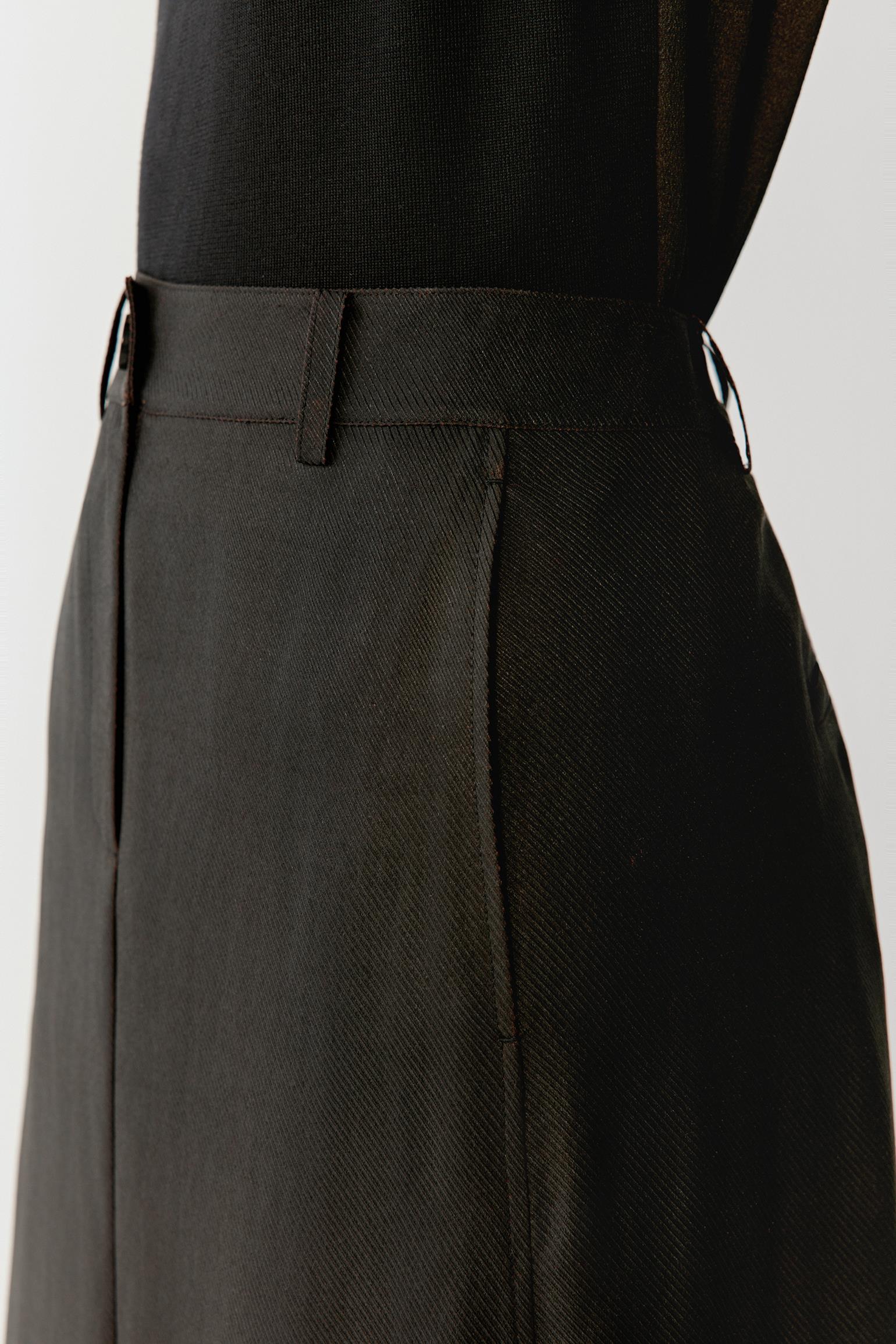 Close-up of side or back pocket showing visible stitching, tonal depth and the compact woven texture of the fabric surface
