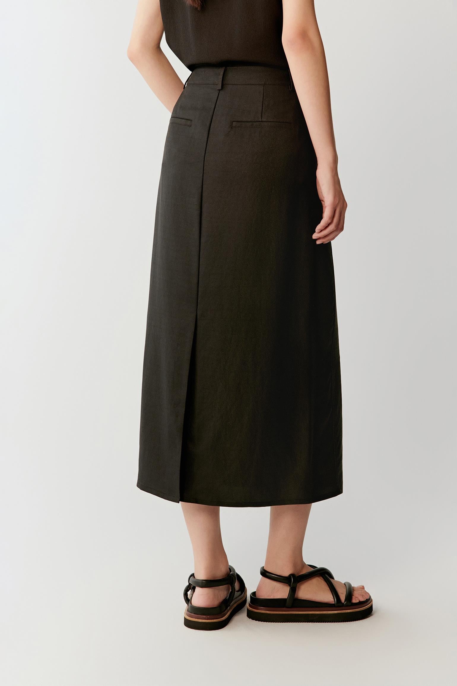 Full-length back view showing the central back vent and clean line of the skirt, highlighting the fluid drape and lightly textured matte surface