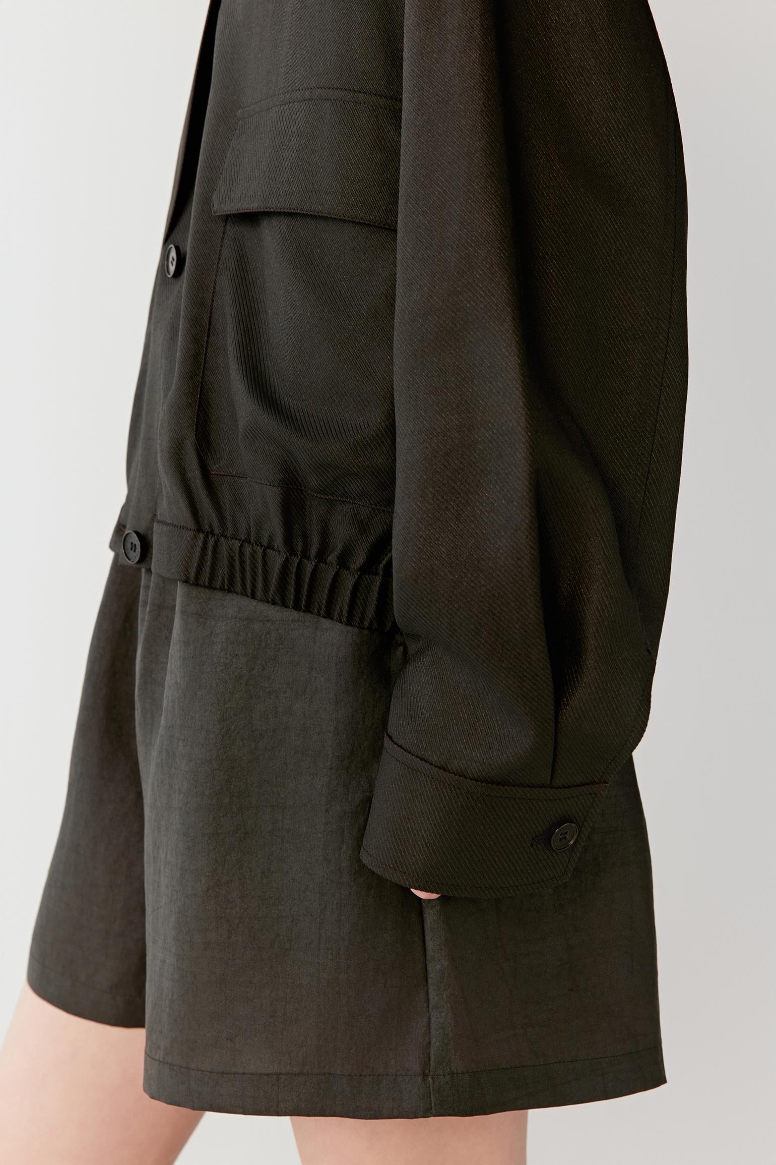Close-up of pocket and lower hem showing the patch pocket construction, elasticated hem detail and lightly textured woven structure characteristic of Gambiered Canton Gauze