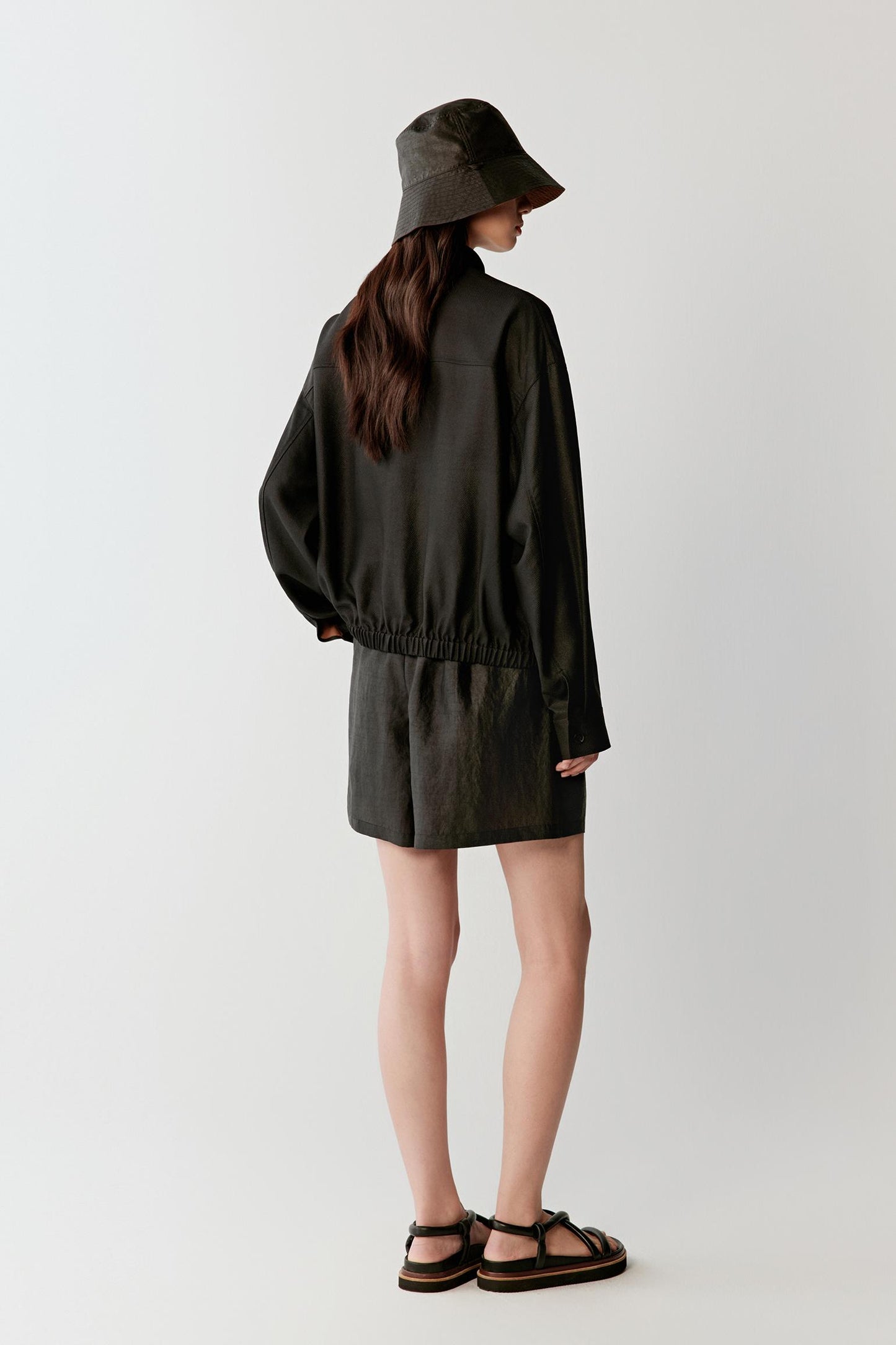 Full-length side or three-quarter view highlighting the relaxed fit, cuffed sleeves and fluid movement of the lightweight woven fabric around the body