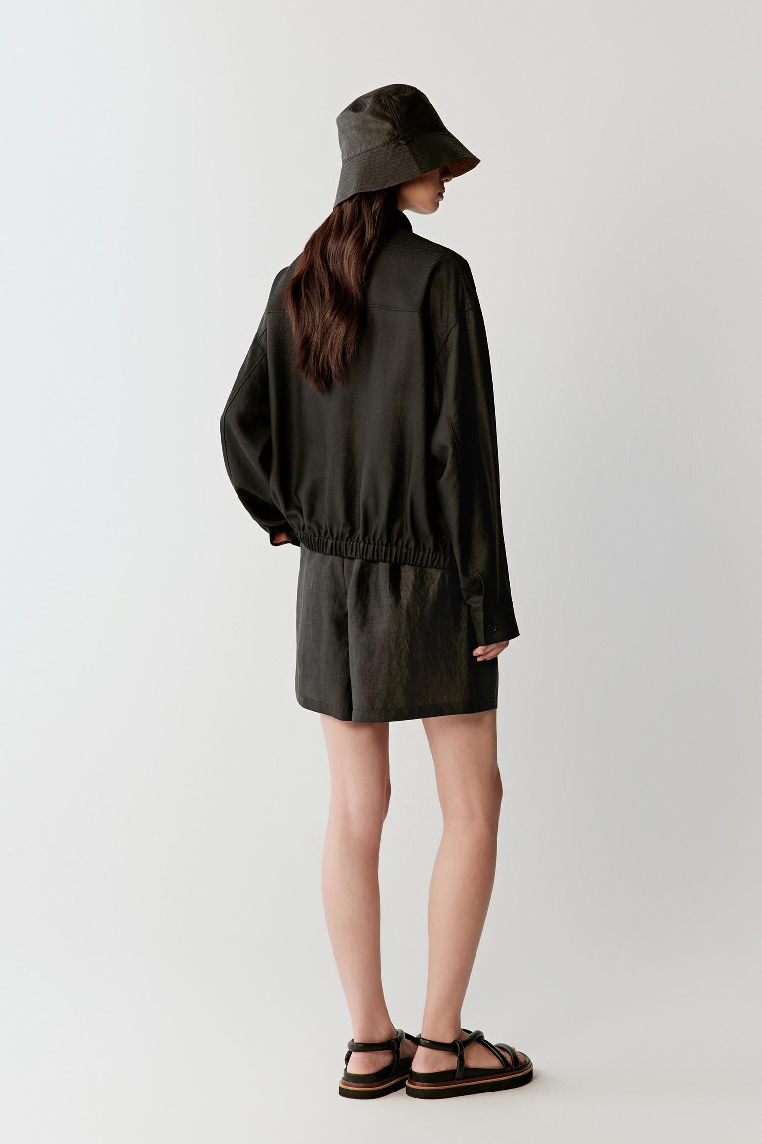 Full-length side or three-quarter view highlighting the relaxed fit, cuffed sleeves and fluid movement of the lightweight woven fabric around the body