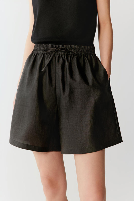 Front or three-quarter view emphasizing the elasticated drawstring waistband and relaxed silhouette, showing the soft movement of the fabric