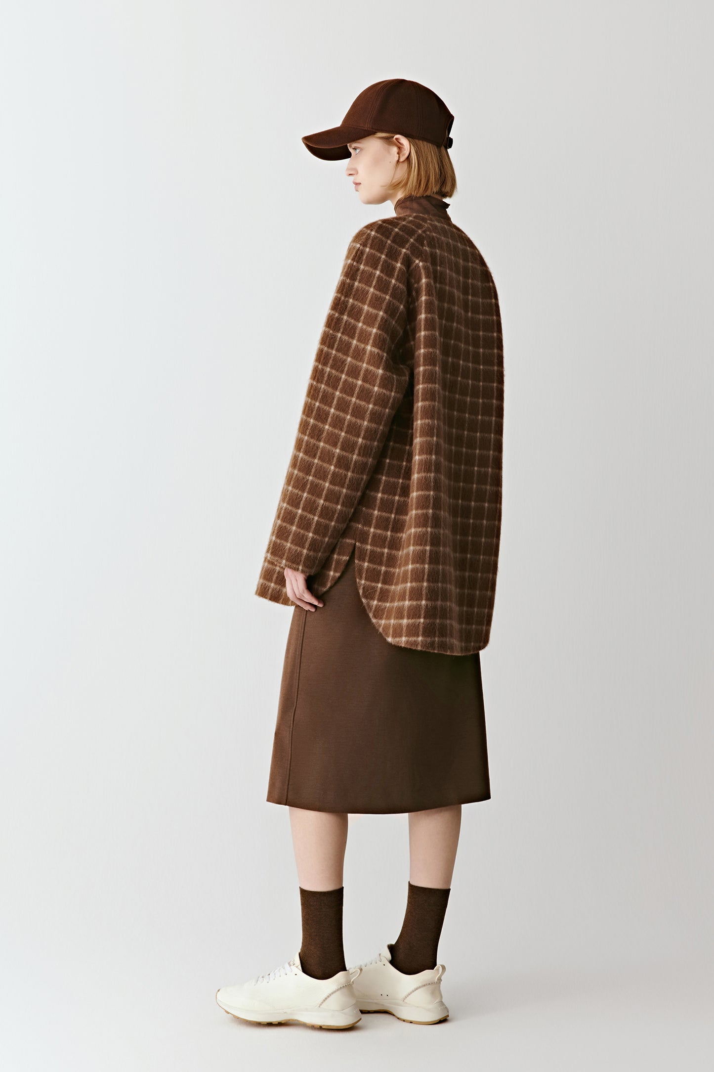 Back view of the short checked double-faced wool coat, showing the check pattern and straight hem.
