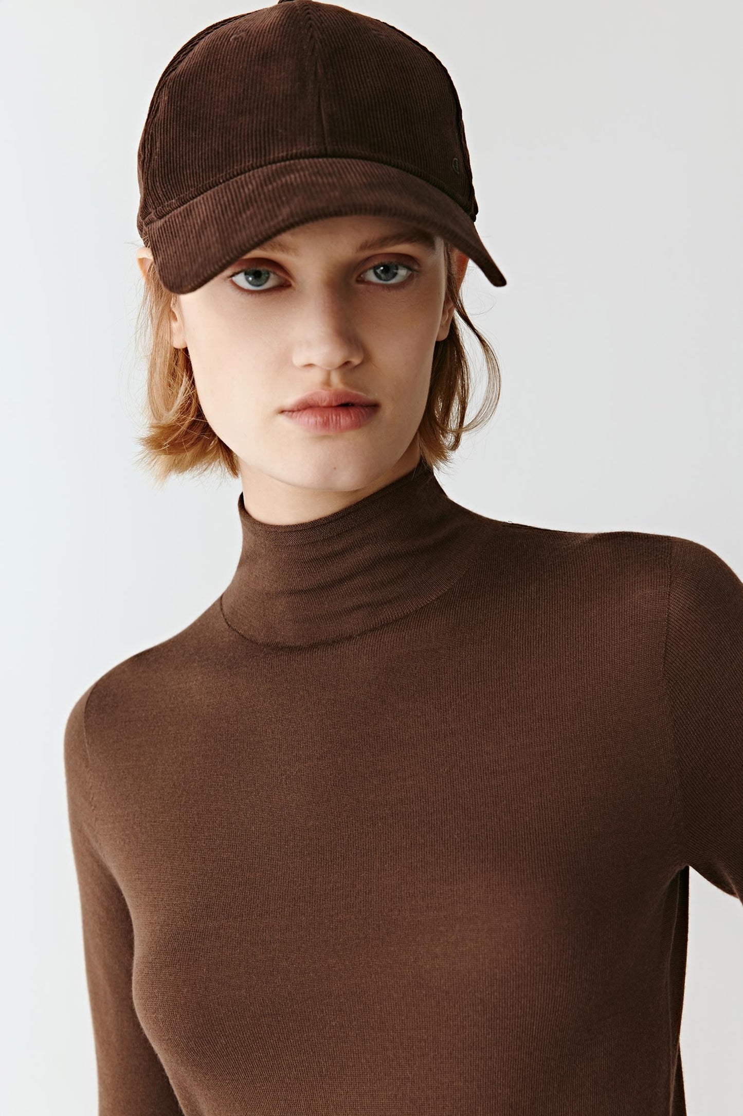Close-up of the merino wool mock-neck, showing the fine dense weave and warm color.