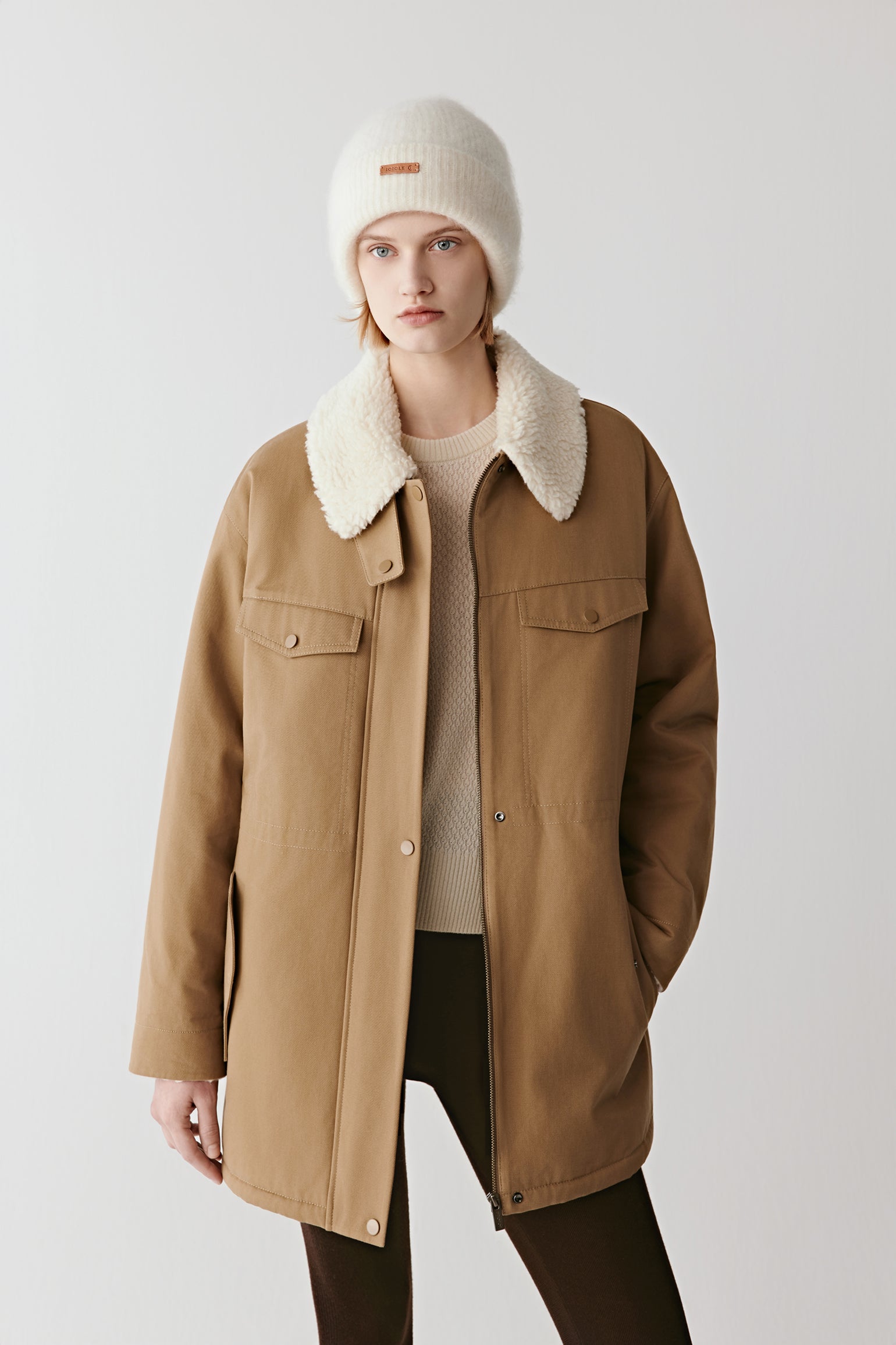 Three-quarter view showing the cotton twill parka’s shearling-effect collar, flap pockets, and relaxed fit.