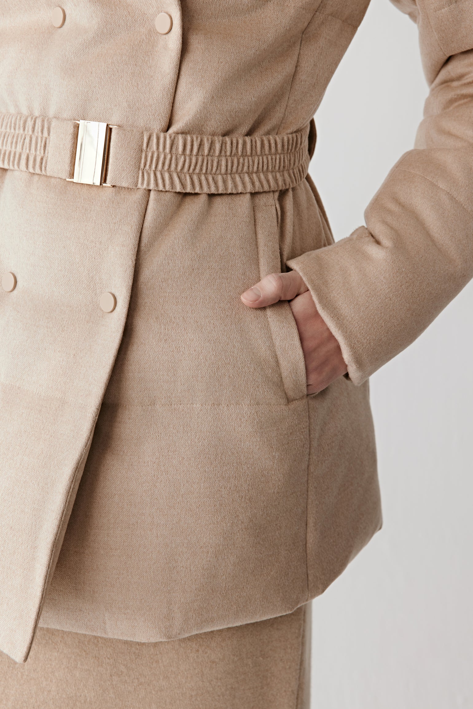 Detail close-up of the side pocket and tweed texture on the camel and silk tweed down coat.