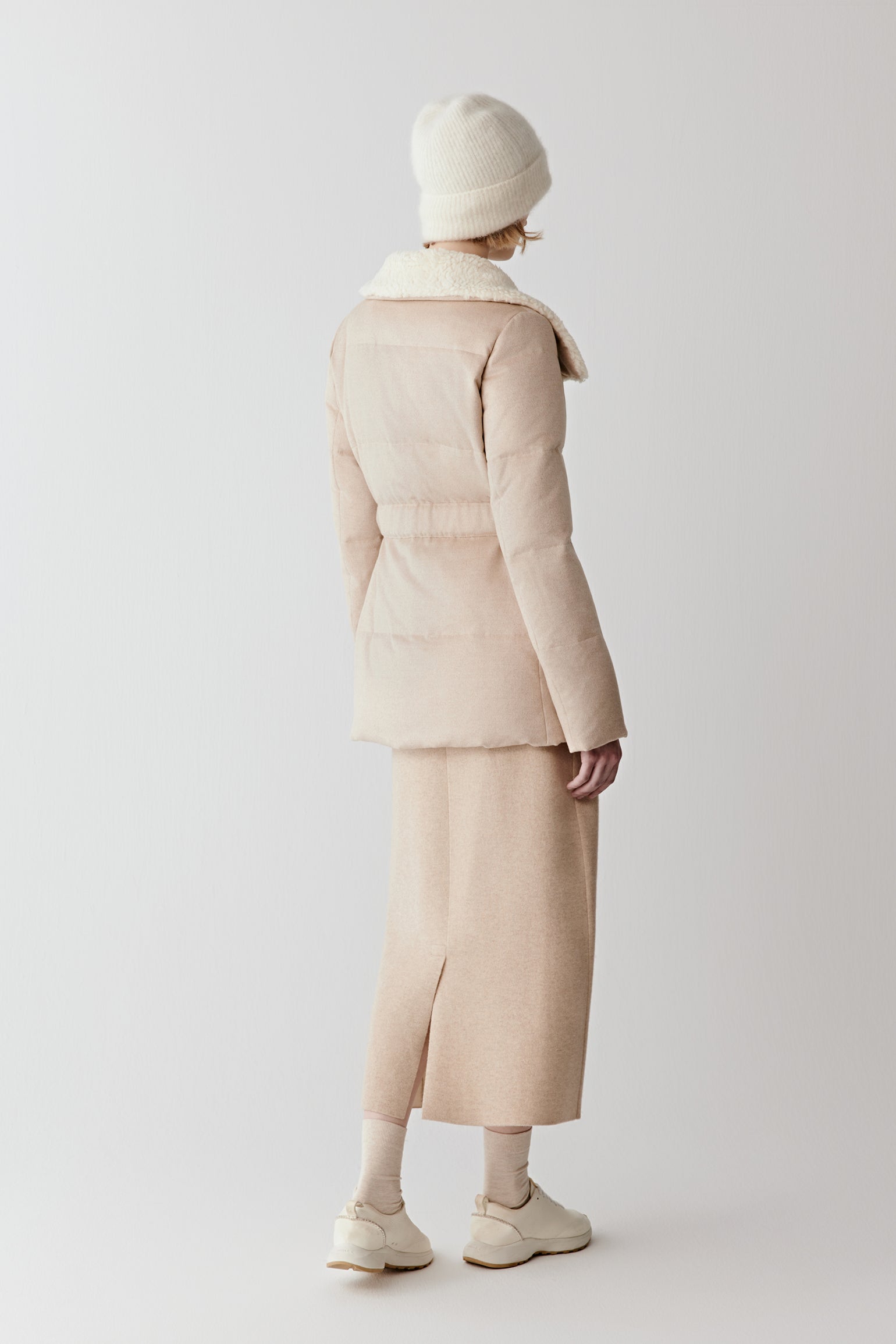 Back view of the padded camel and silk tweed down coat, highlighting the straight cut and refined proportions.