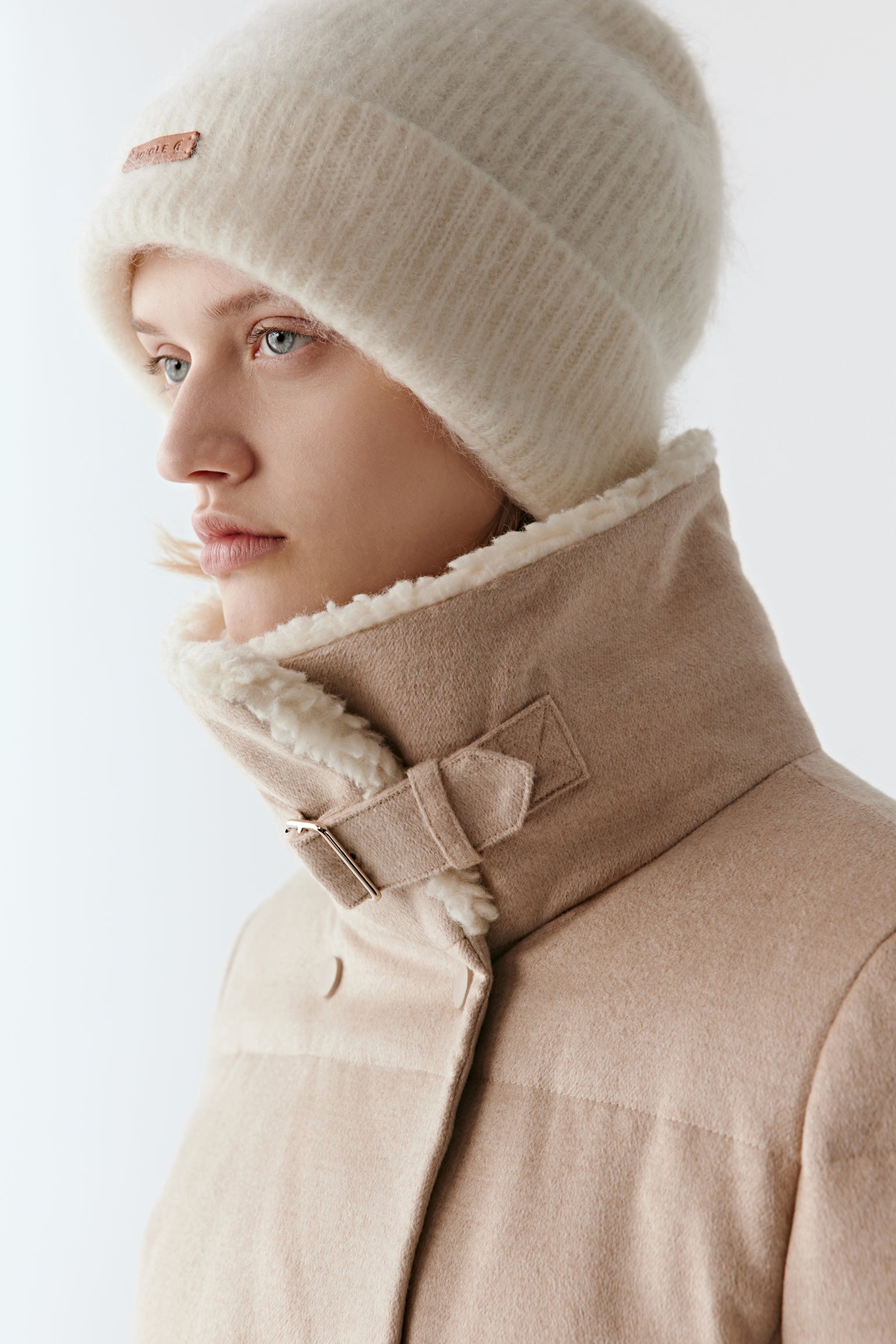 Close-up of the high collar lined with a wool-effect finish on the camel and silk tweed down coat.