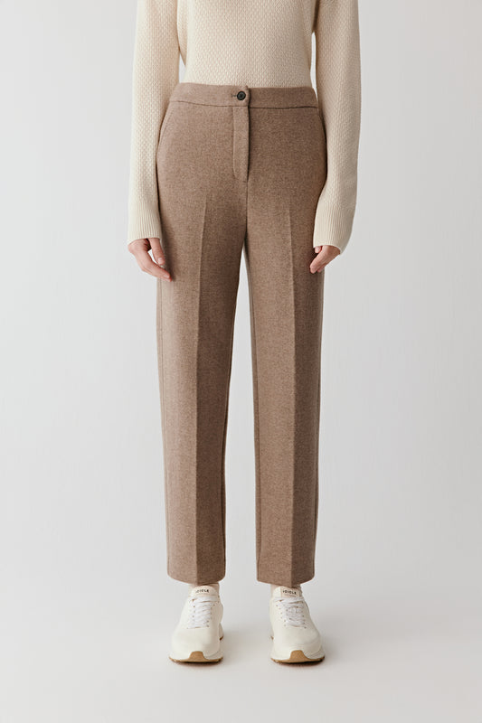 Front view from waist to ankle showing the crisp cut and defined pleats of the trousers.
