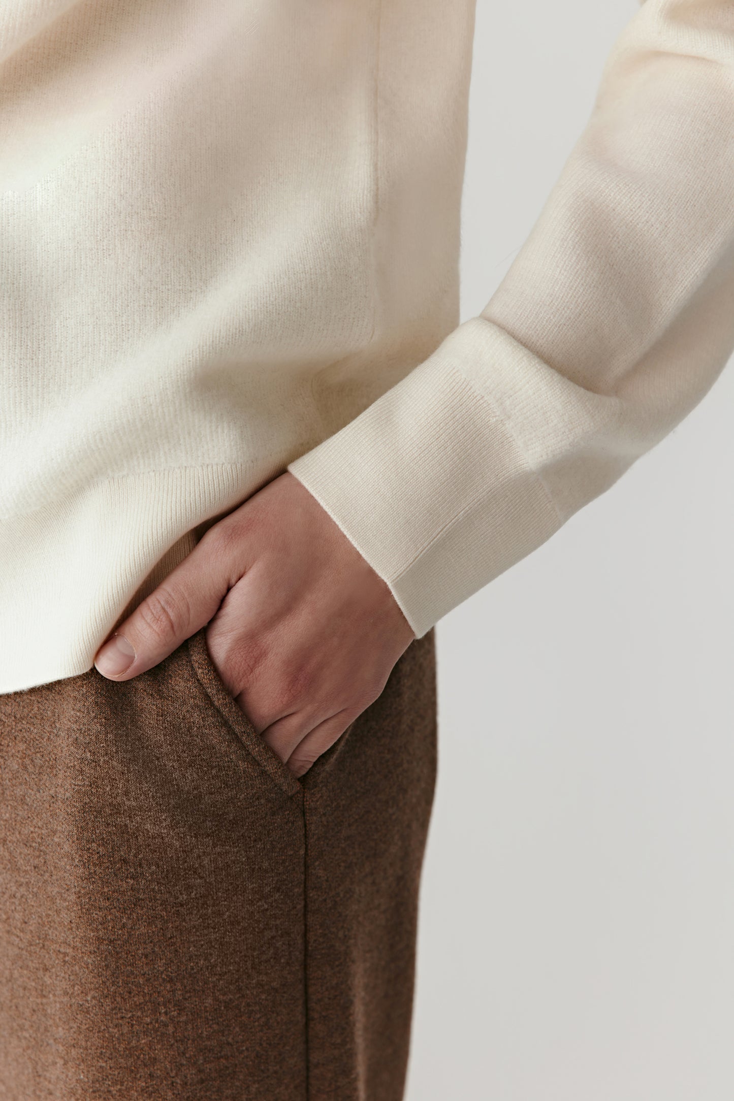 Detail close-up of the sleeve and hem of the worsted wool pullover, highlighting the clean knit finish.