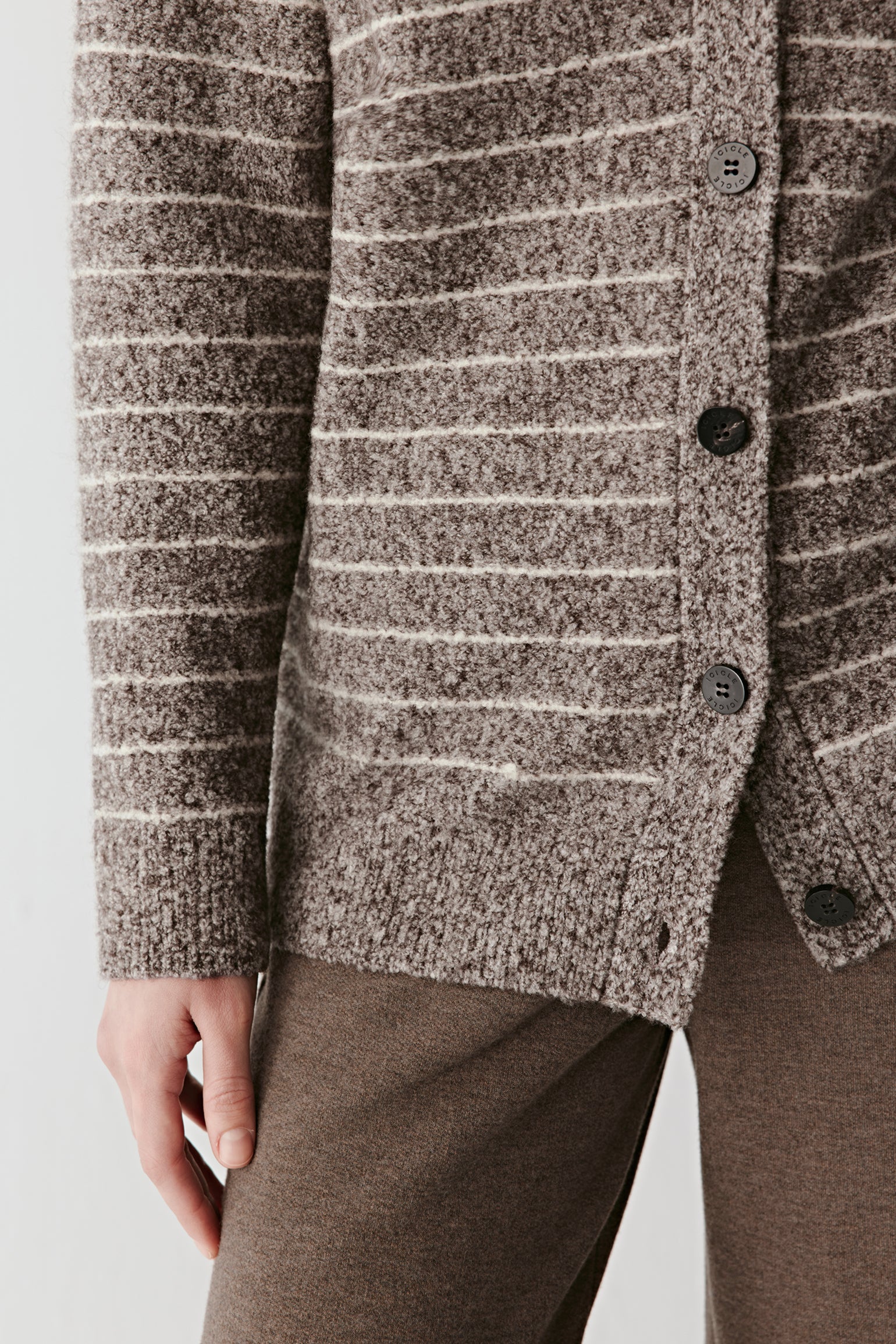 Detail close-up of the striped knit fabric, highlighting the looped yarn texture and natural fibre blend.