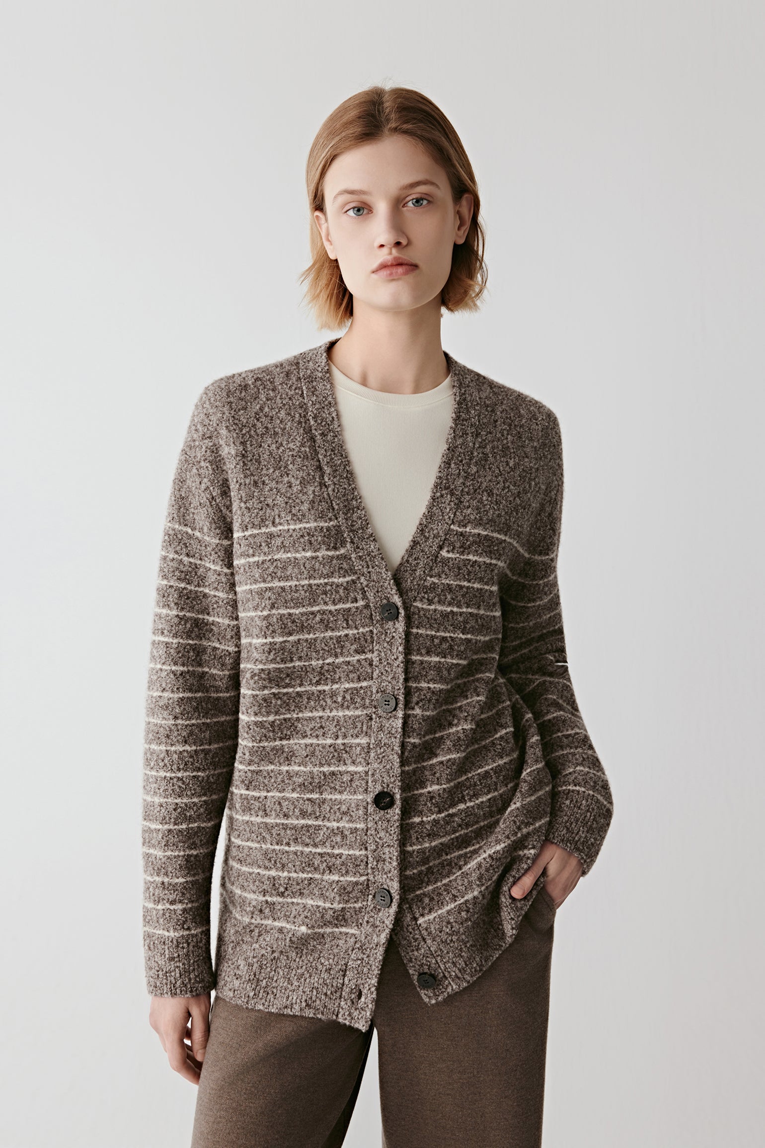 Front view of a striped wool and yak cardigan in natural brown and off-white tones, featuring a V neckline and tonal button placket.