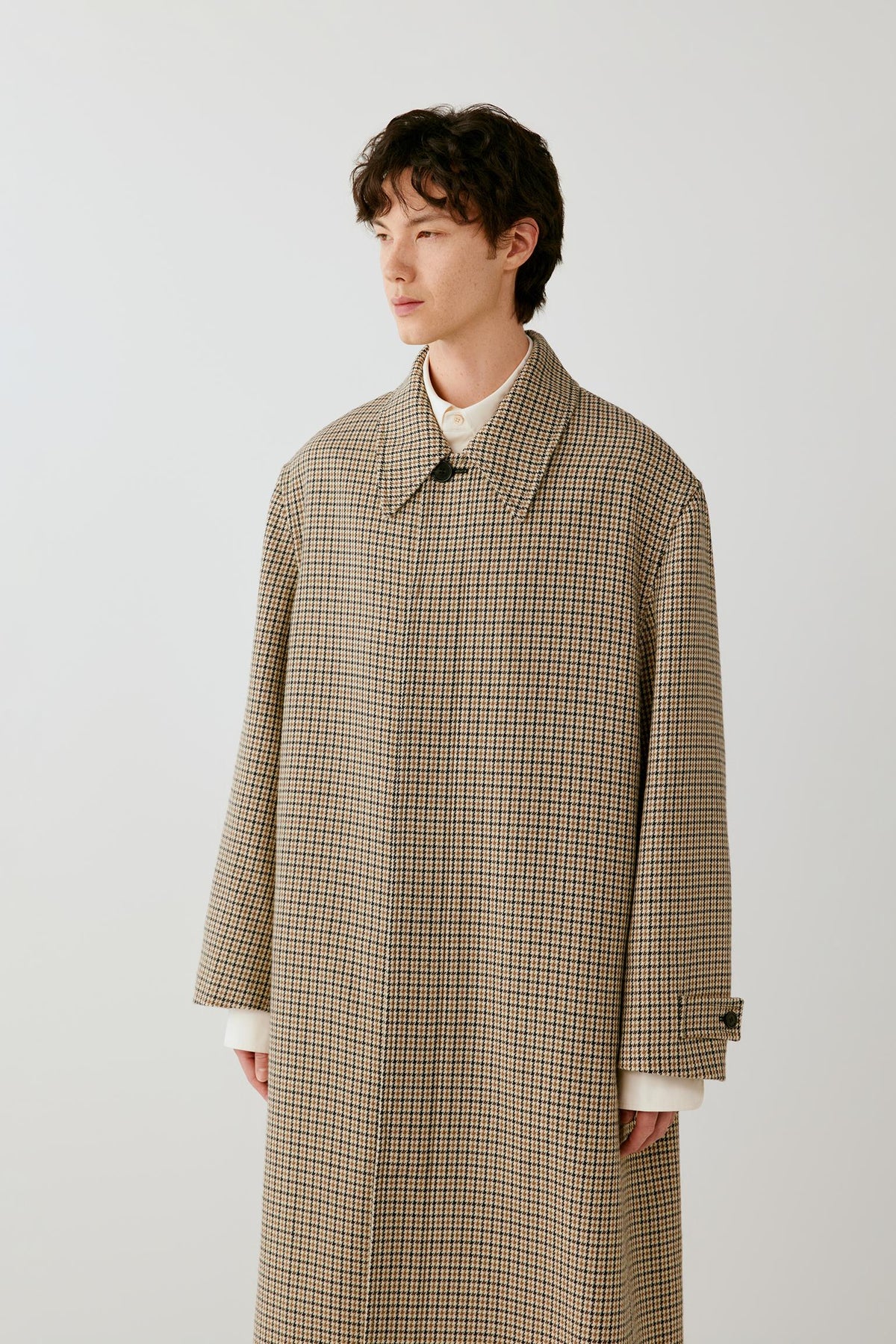 Three-quarter front view highlighting the relaxed cut, pointed collar and woven houndstooth pattern.