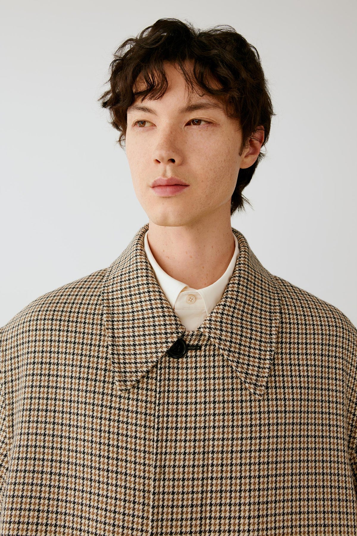 Close-up highlighting the pointed collar and beige and black woven houndstooth pattern.