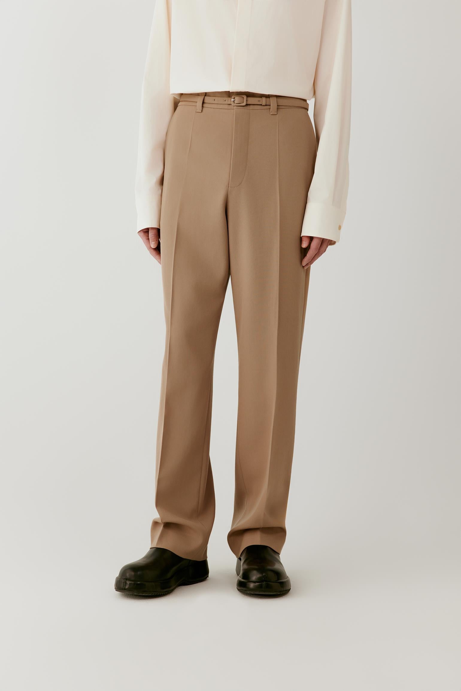 Front view focused on the trousers, showing the straight-leg cut, pressed creases and structured wool twill fabric.