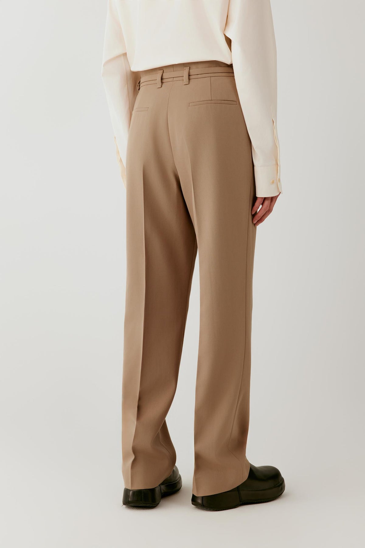 Three-quarter view highlighting the straight-leg silhouette, pressed creases and clean tailoring.