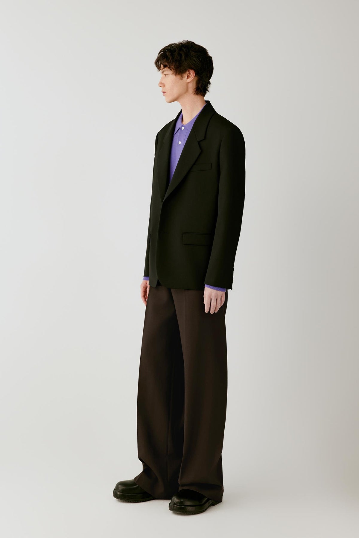 Three-quarter view highlighting the tailored cut, flap pockets and structured drape of the wool twill.