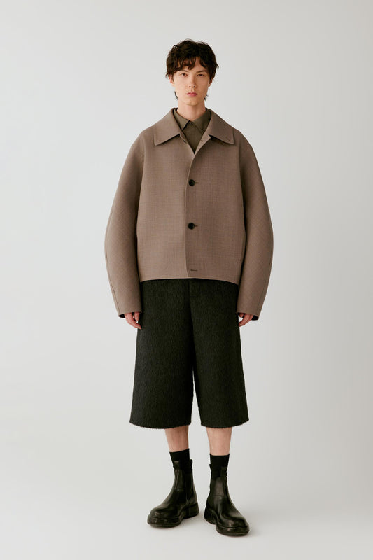 Full-length front view showing the jacket with black shorts, emphasizing the dropped shoulders and clean construction.