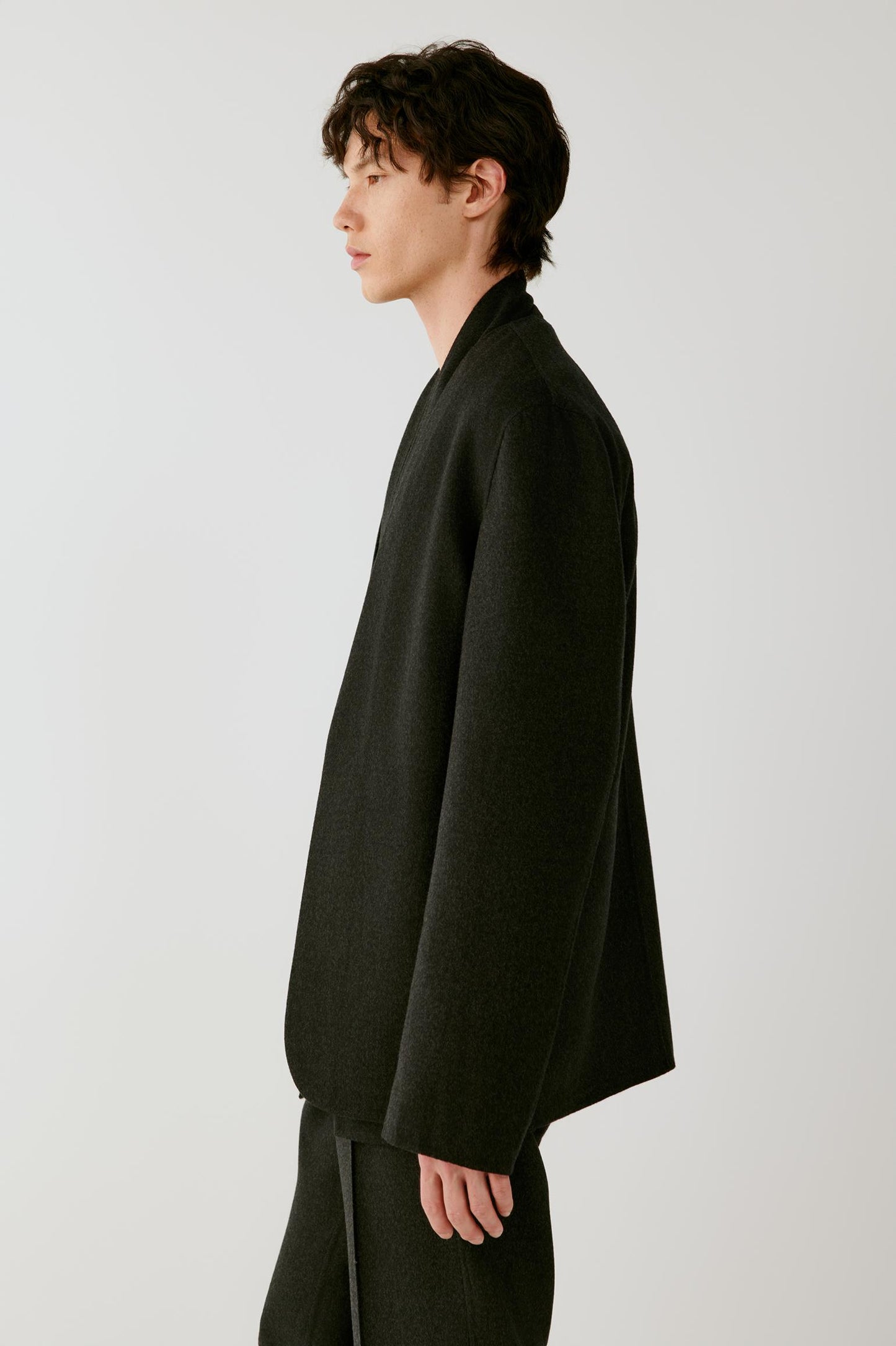 Side view emphasizing the relaxed cut, open-front construction and structured drape of the double-face wool.
