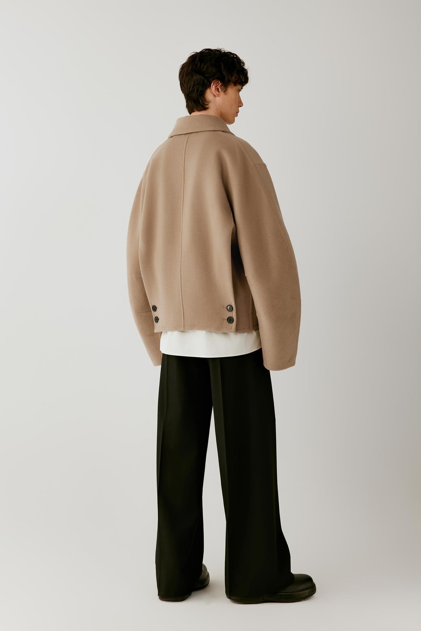 Full-length back view highlighting the clean back construction, dropped shoulders and short silhouette.