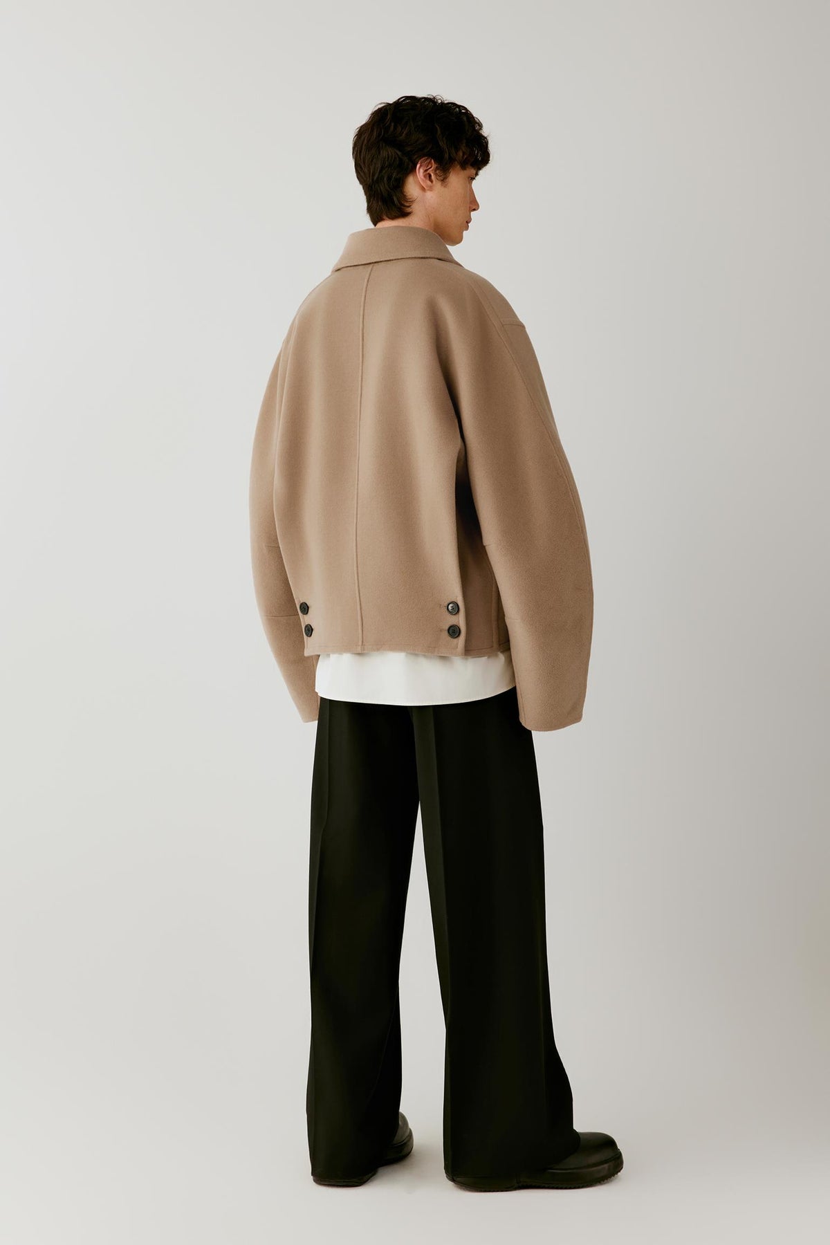 Full-length back view highlighting the clean back construction, dropped shoulders and short silhouette.