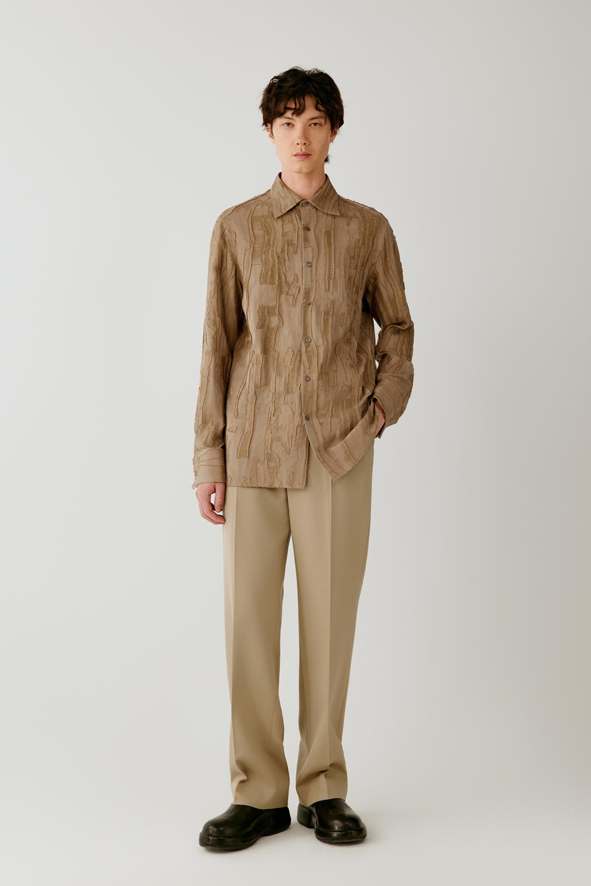 Full-length front view showing the camel jacquard shirt with matching trousers, emphasizing the straight silhouette and textured surface.