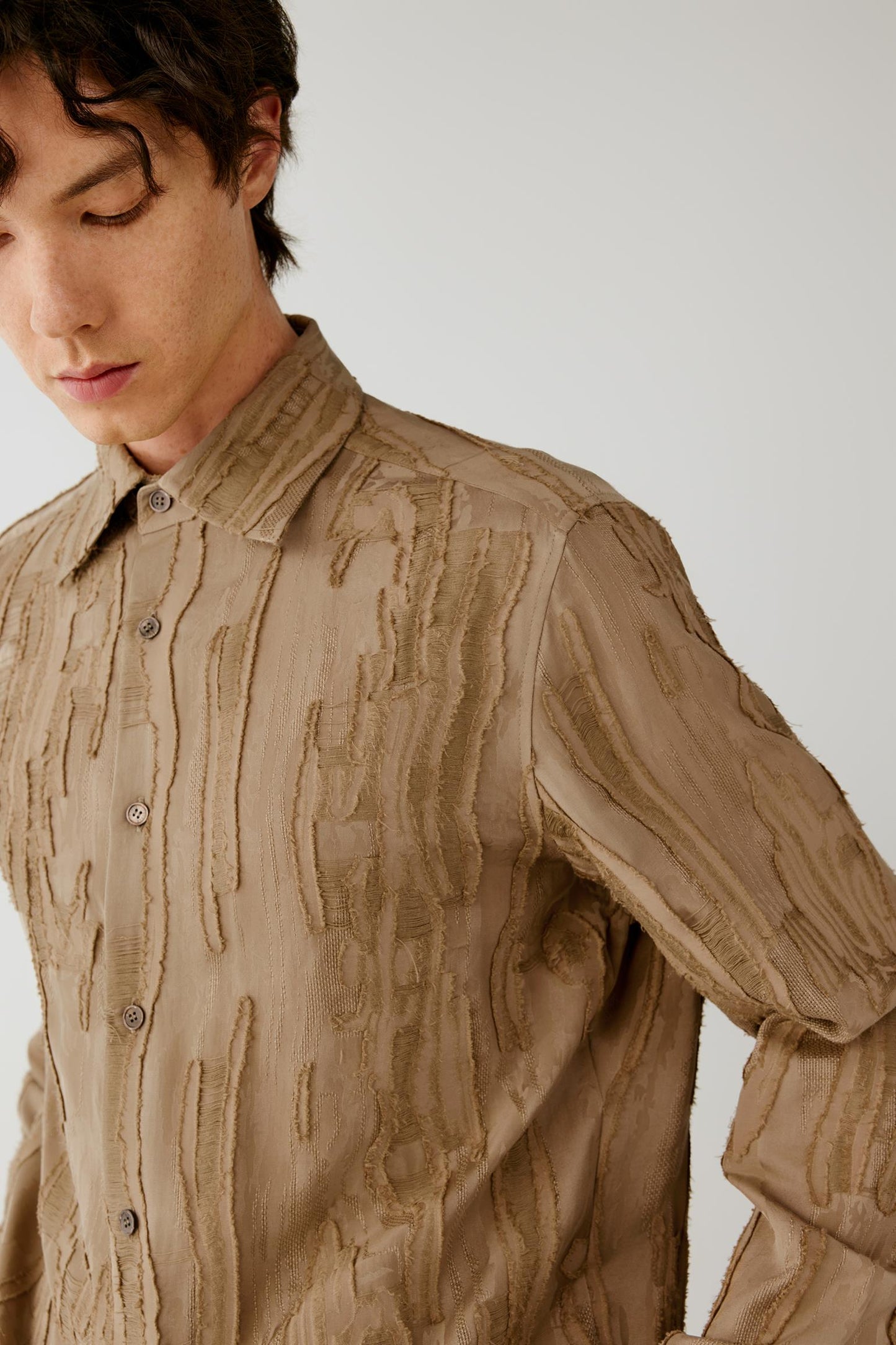 Close-up highlighting the pointed collar, button-front fastening and raised wood-grain jacquard pattern.