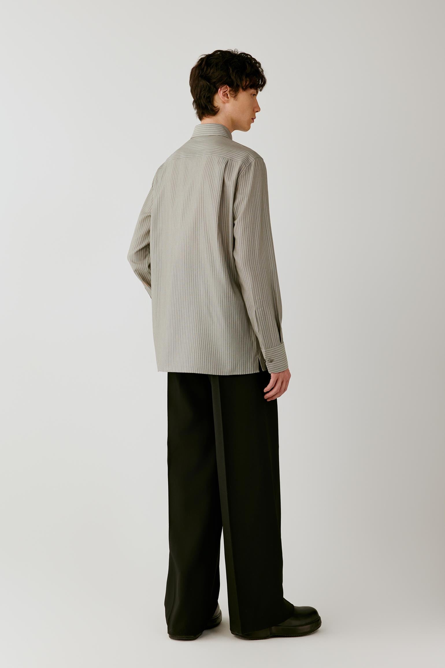 Full-length three-quarter view emphasizing the clean silhouette, vertical stripes and fluid drape of the wool and silk fabric.