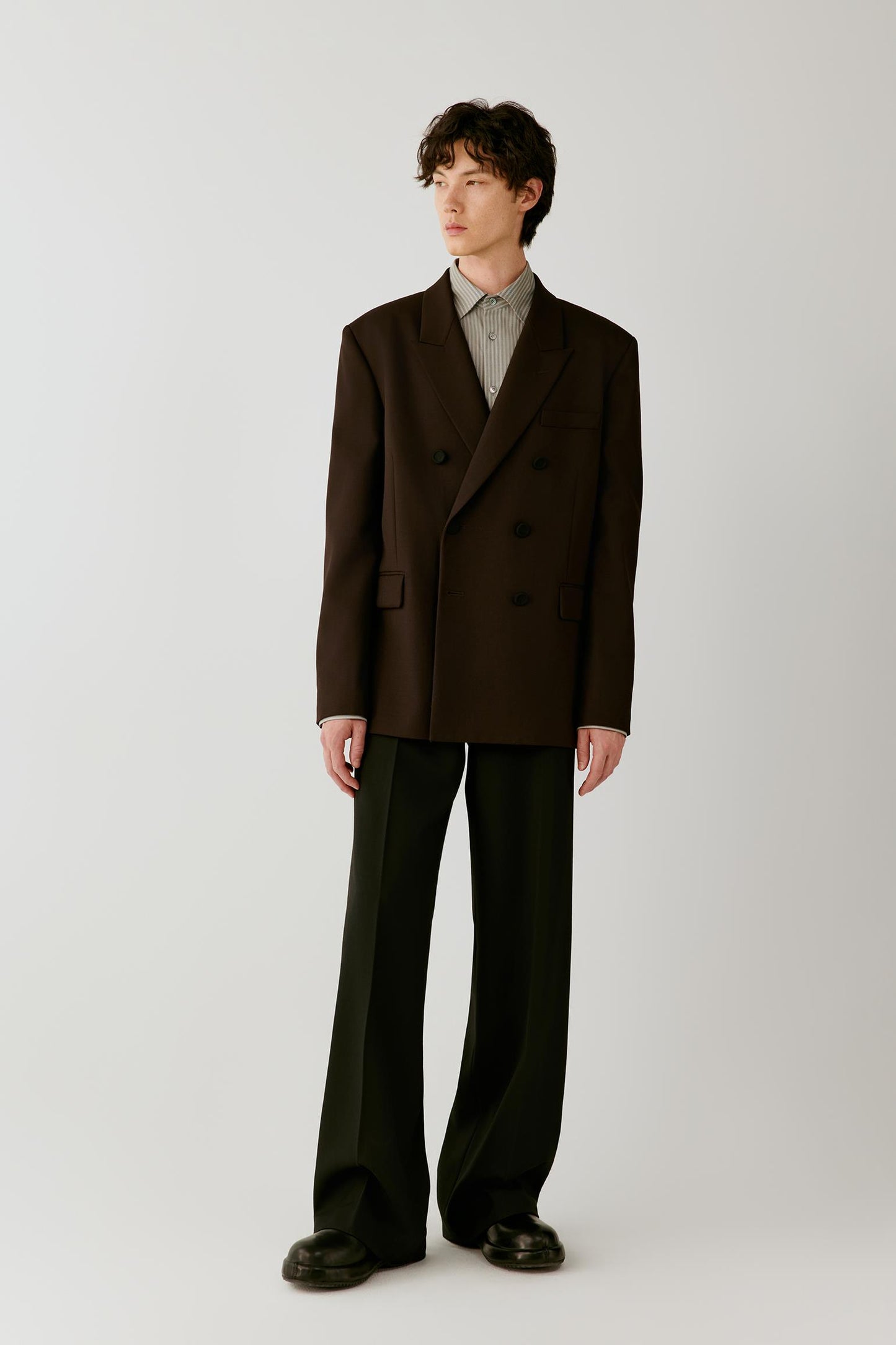Full-length front view showing the wool twill jacket with black trousers, emphasizing the structured silhouette and double-breasted fastening.