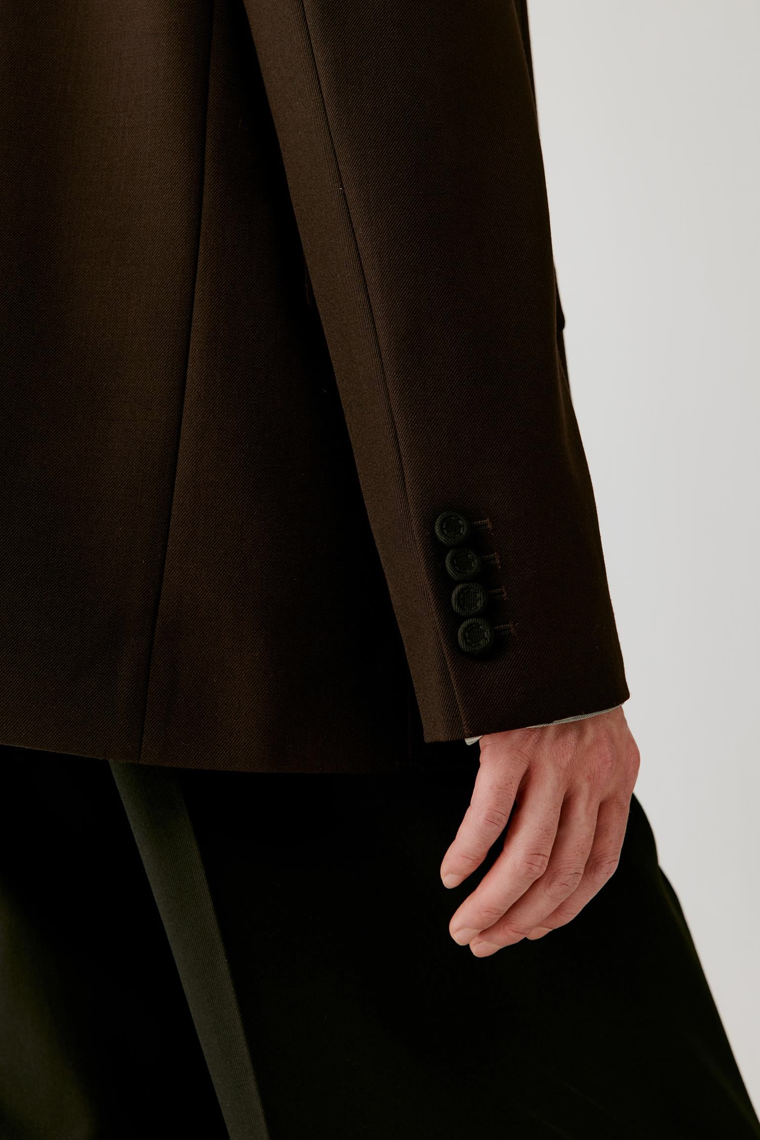 Close-up of the sleeve and cuff, showing the structured wool twill fabric and clean finishing.