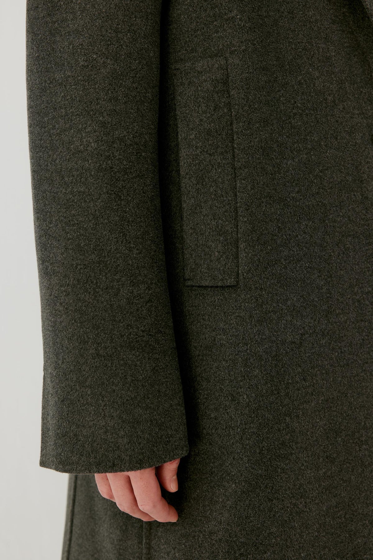 Close-up of the sleeve and cuff, showing the textured double-face wool surface and clean finish.