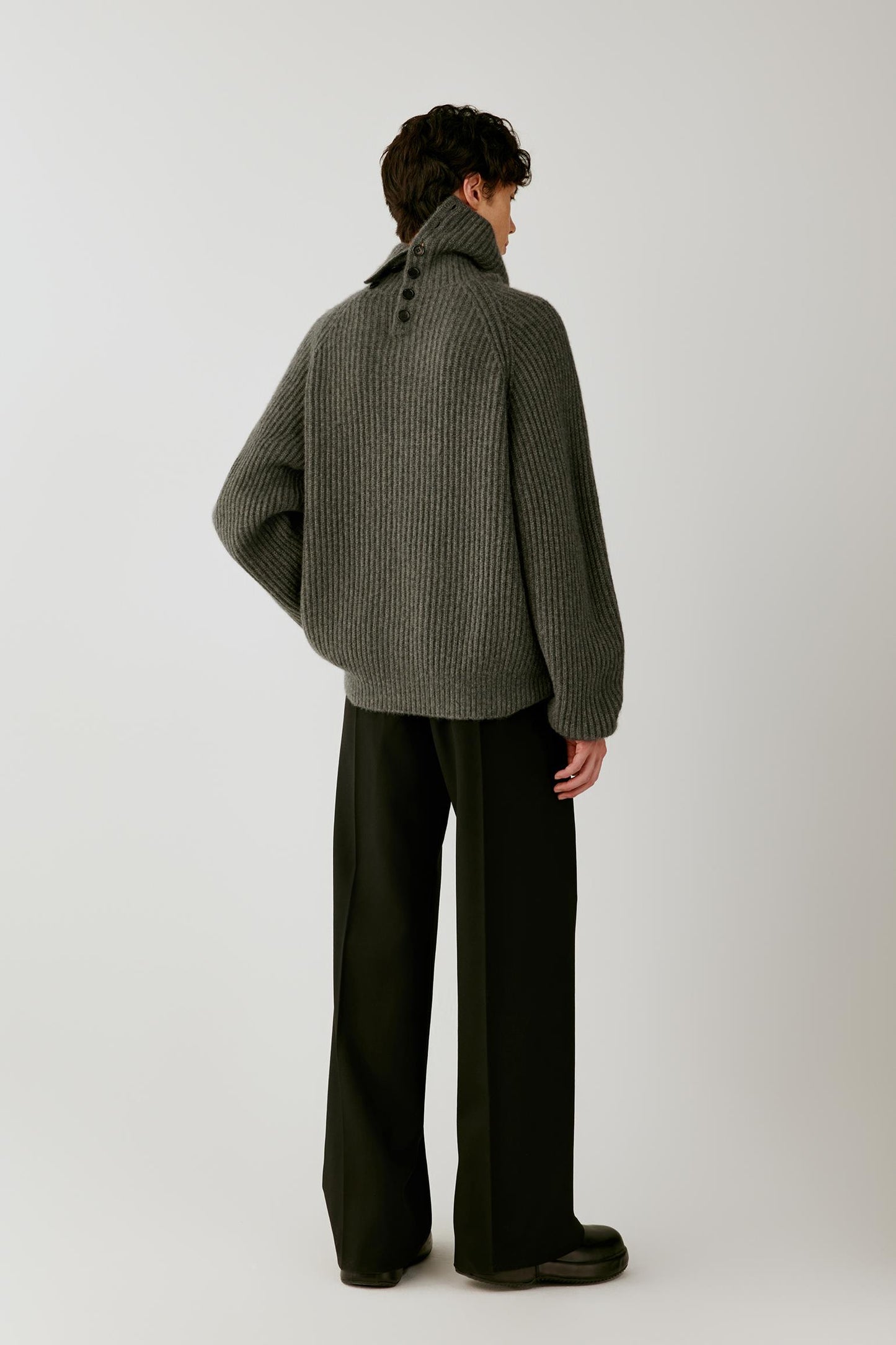 Back view highlighting the relaxed oversized silhouette, raglan sleeves and ribbed texture.