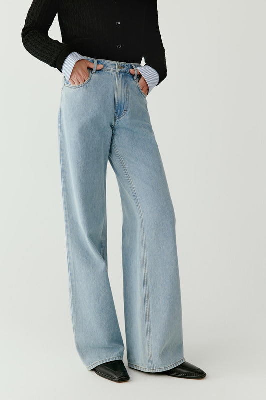 Side view emphasizing the elongated silhouette and the soft fall of the denim fabric.