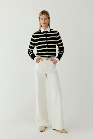 Front view of a model wearing wide-leg jeans crafted from undyed Earth Denim in an off-white shade. The jeans feature a wide-leg silhouette with clean lines and a structured waistband.