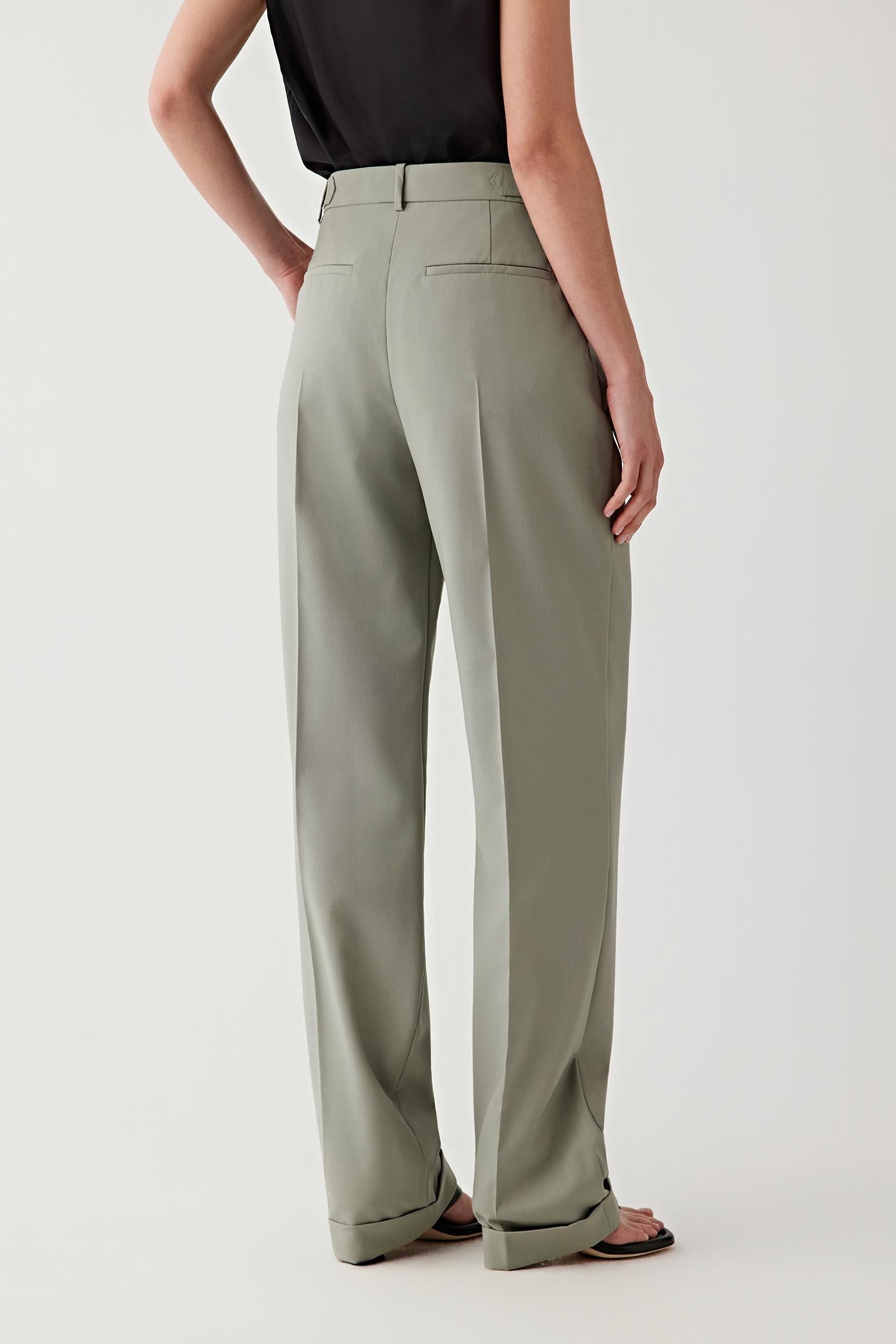 Person wearing light green pants on a white background