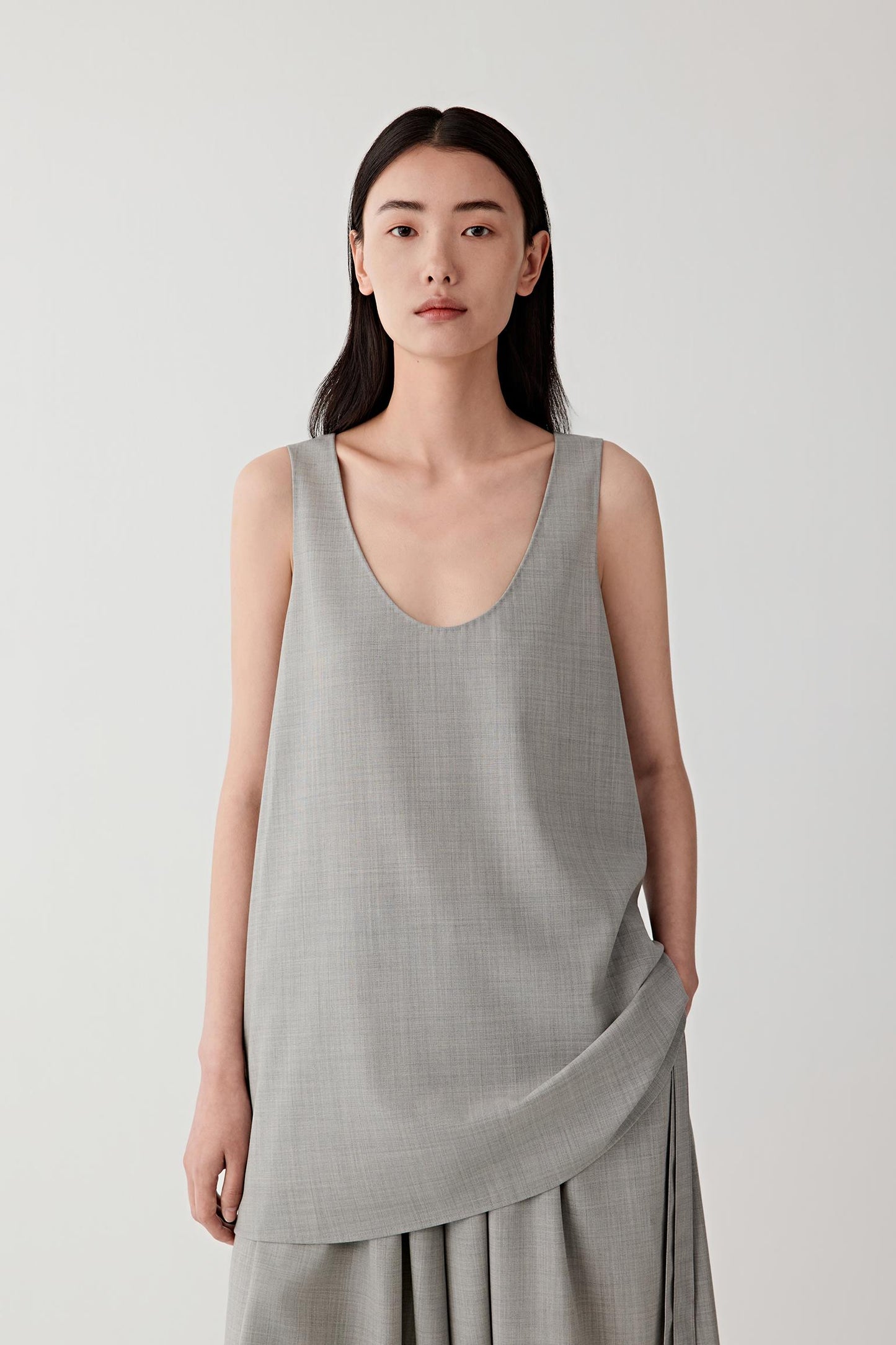 Three-quarter view highlighting the minimal neckline and fluid shape.