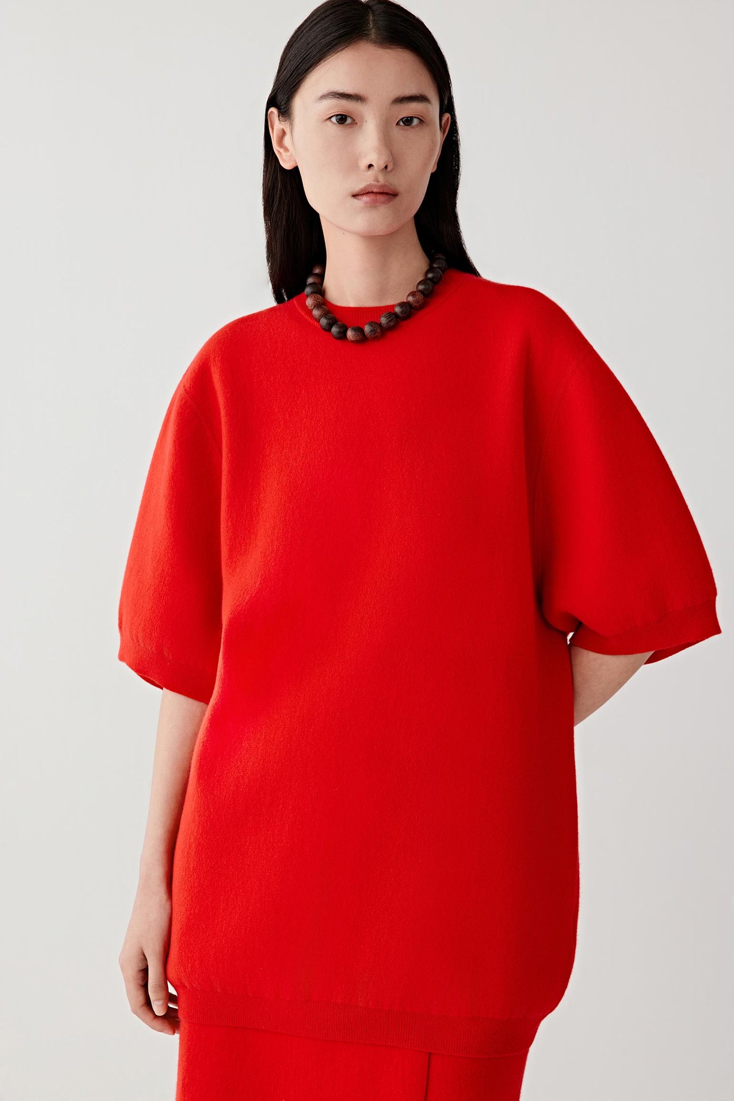 Person wearing a red outfit on a plain background