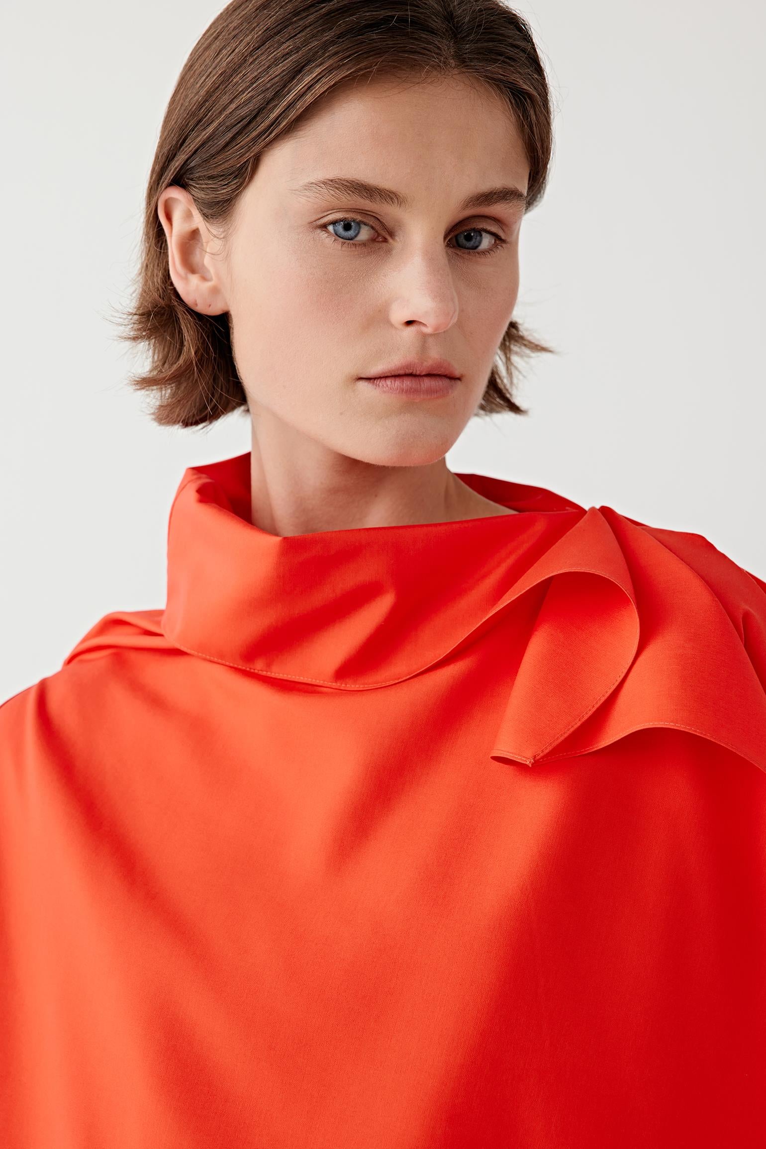 Close-up portrait focusing on the draped collar and upper silhouette, detailing the smooth spun silk surface and subtle sheen