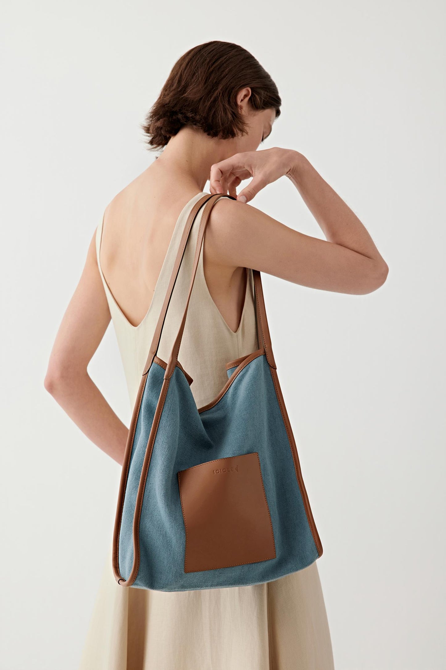 Side view emphasizing volume, flexible body and interaction between structured leather panel and soft fabric