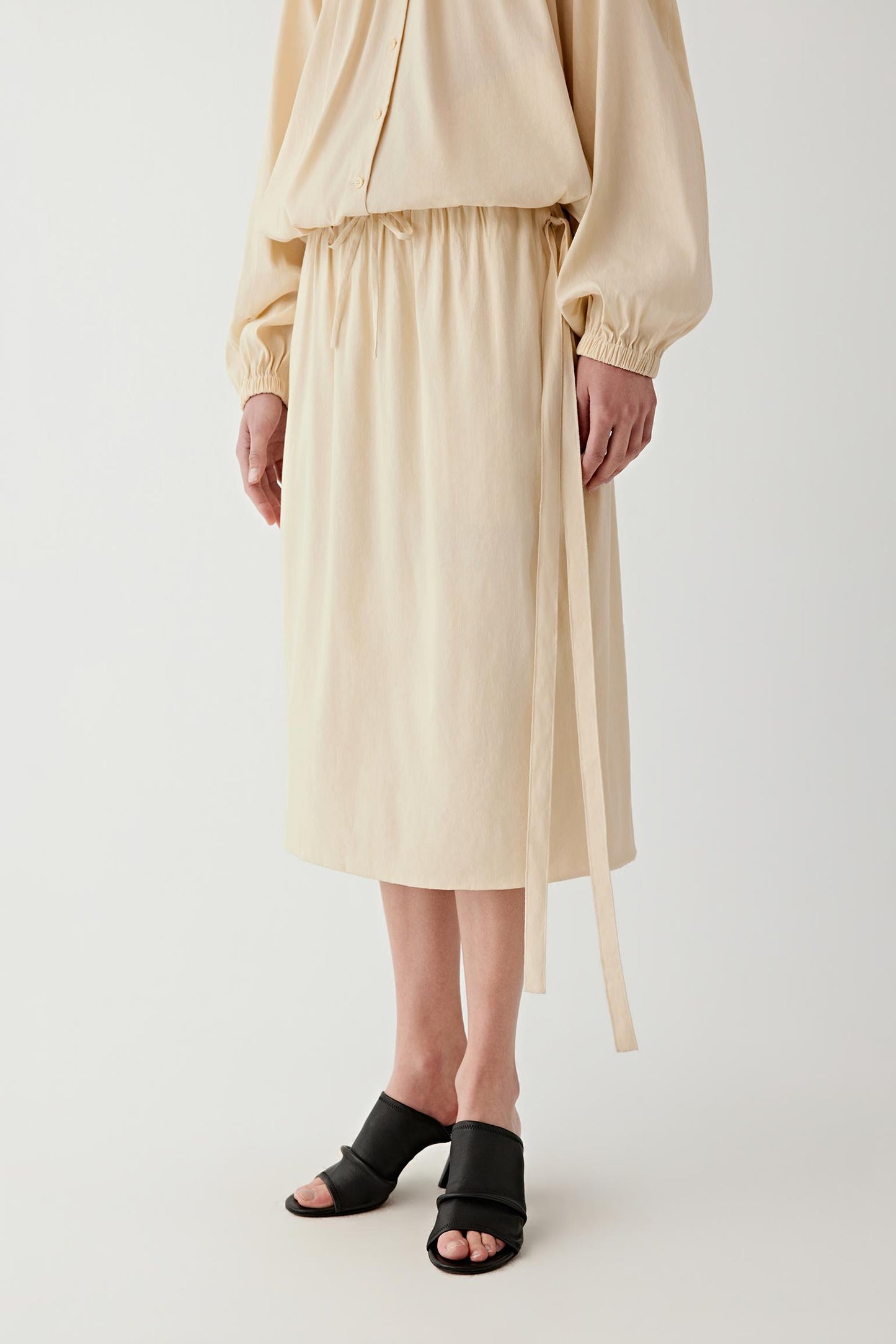 Full-length front view with slight movement, emphasizing the airy volume of the skirt, the way the fabric opens gently from the waistband and the natural flow created by the lightweight woven construction
